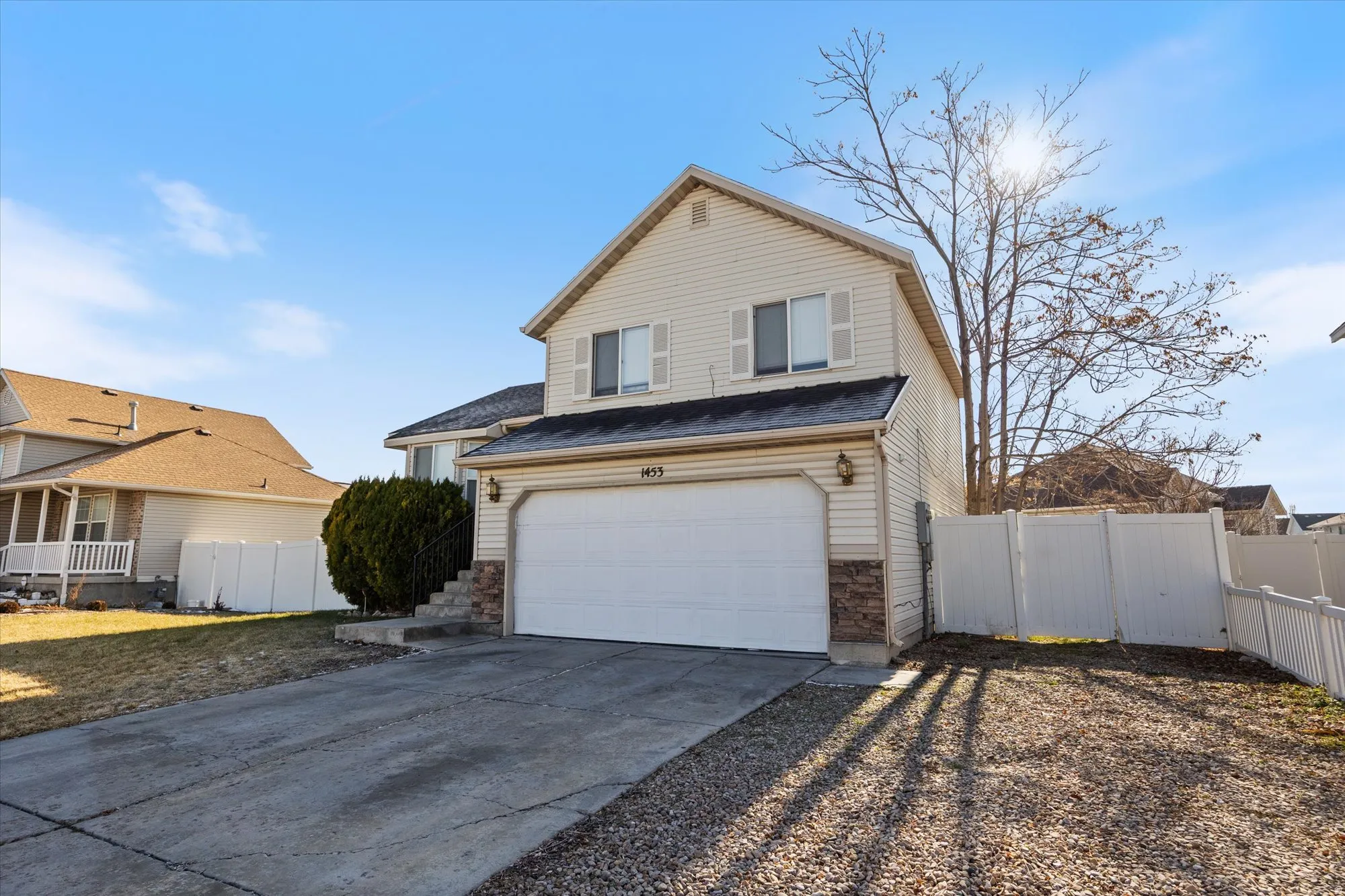 View of front of home with concrete driveway and an attached garage