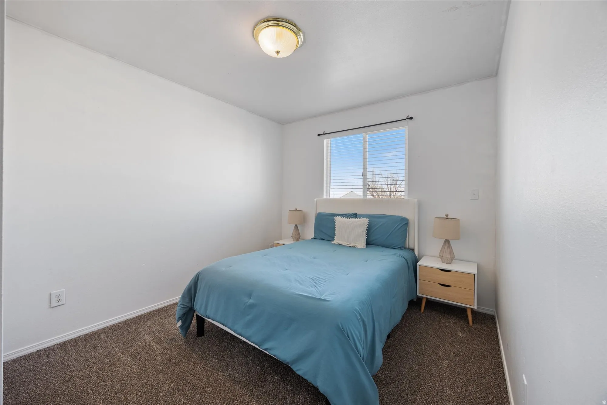 Bedroom featuring dark carpet and baseboards