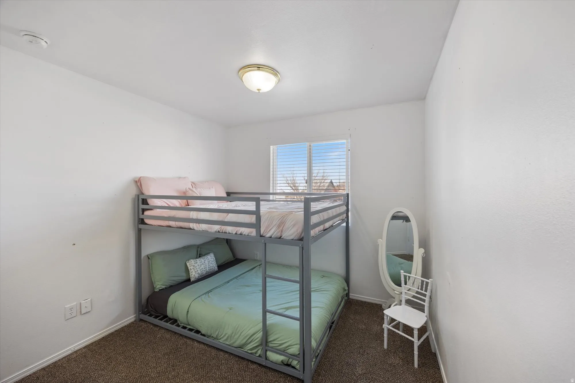 Bedroom featuring dark carpet and baseboards