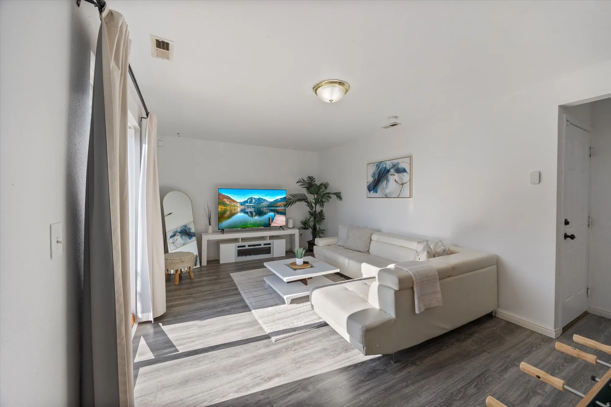 Living room with dark wood-style flooring and baseboards