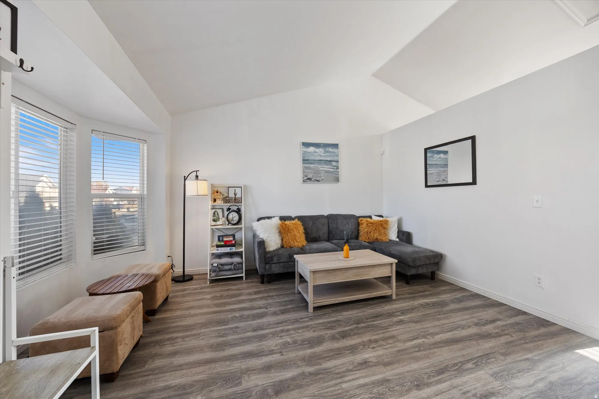 Living area featuring vaulted ceiling and dark wood-style flooring