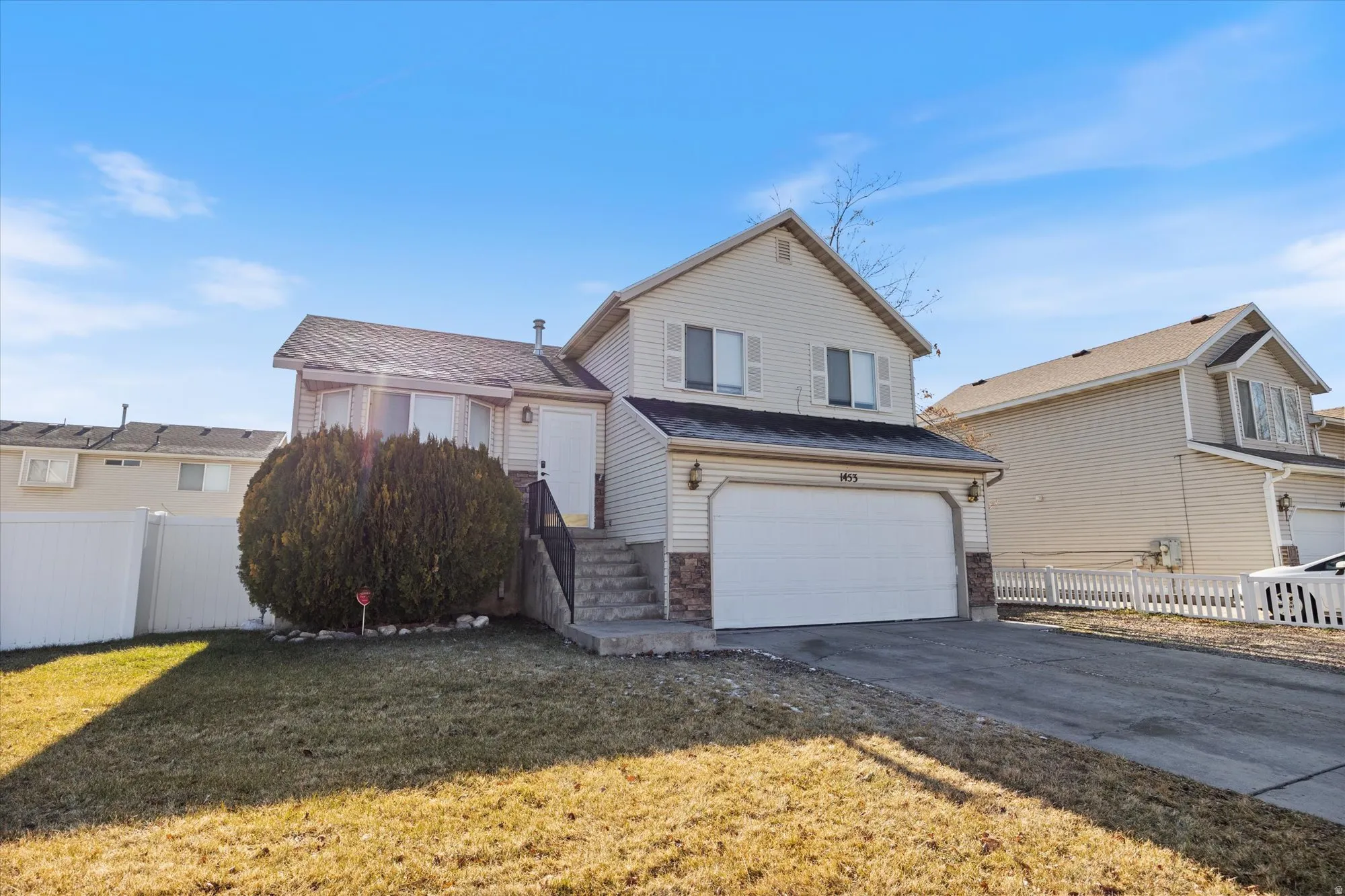 View of front facade with concrete driveway and a garage