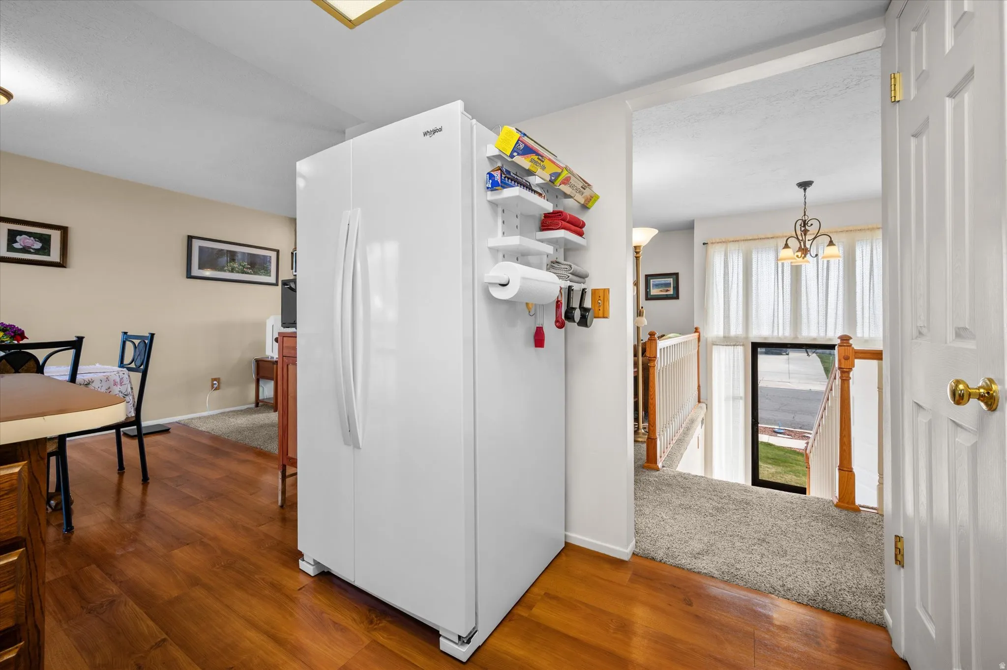 Kitchen featuring freestanding refrigerator, dark wood-style flooring, and hanging lights