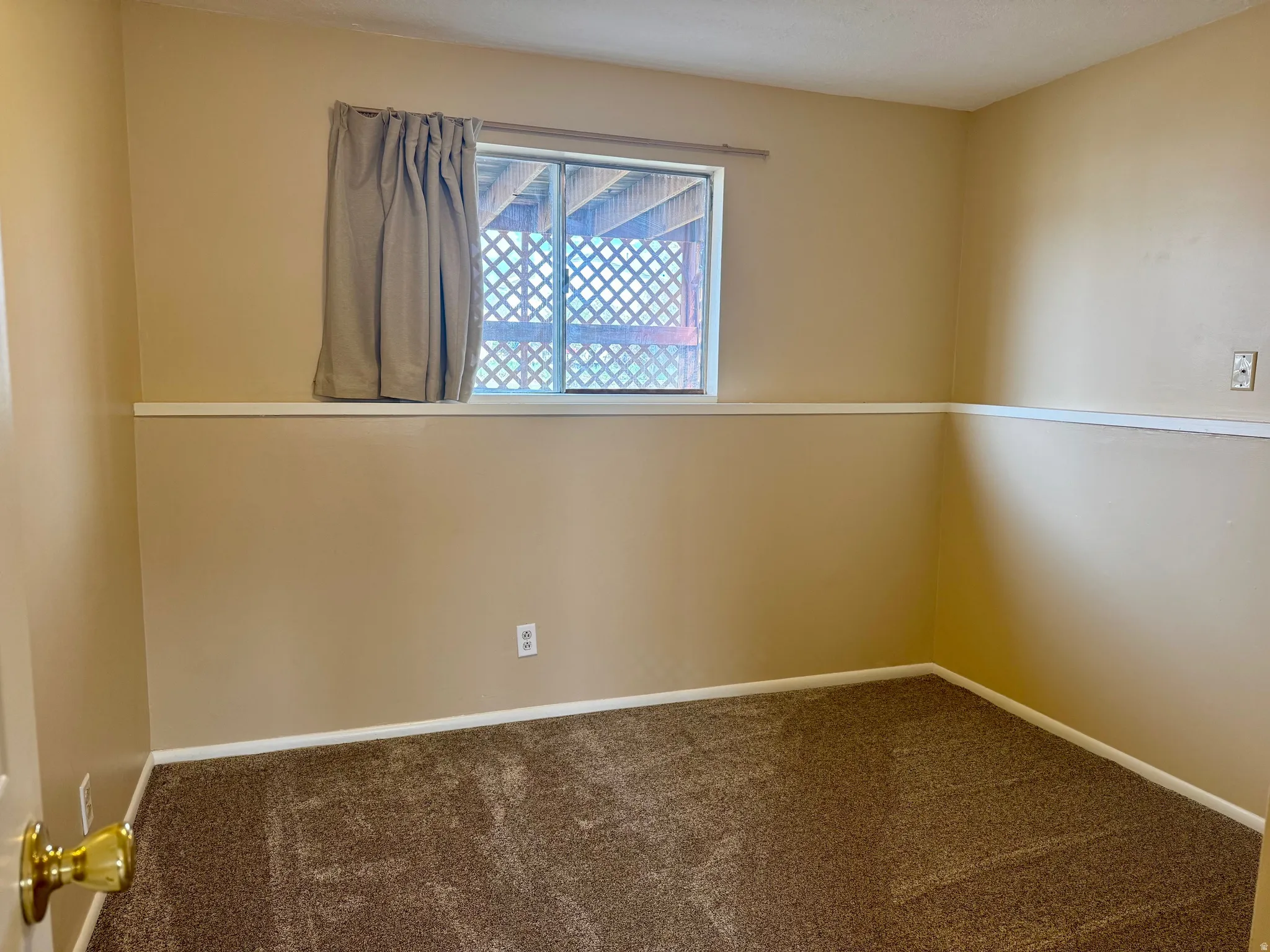 Unfurnished room with dark carpet and baseboards