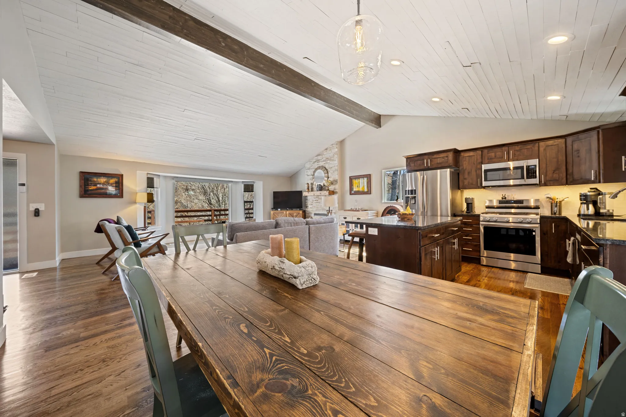 Dining area featuring lofted ceiling with beams and dark wood-style floors
