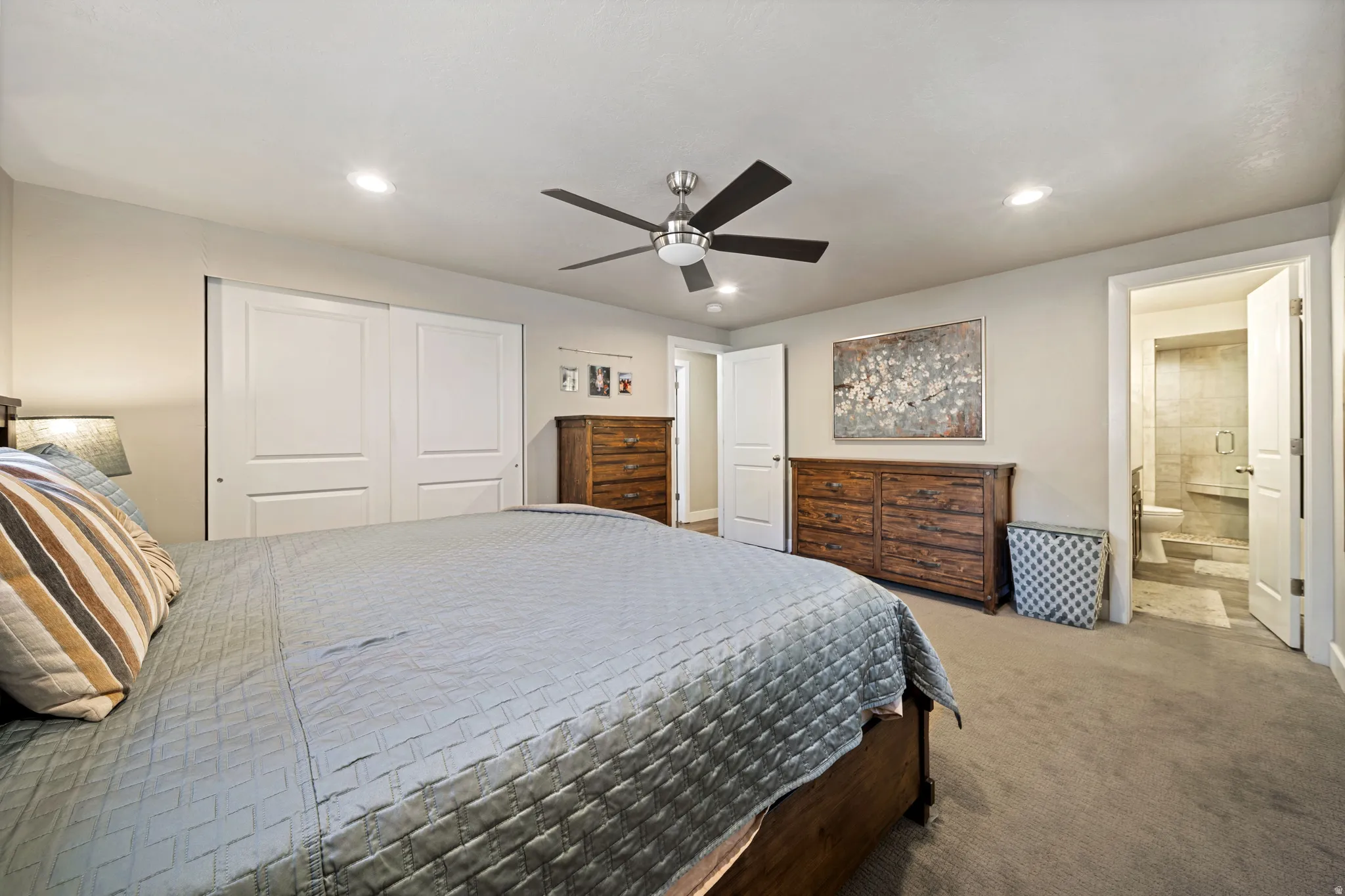 Carpeted bedroom with a closet, ceiling fan, recessed lighting, and ensuite bathroom