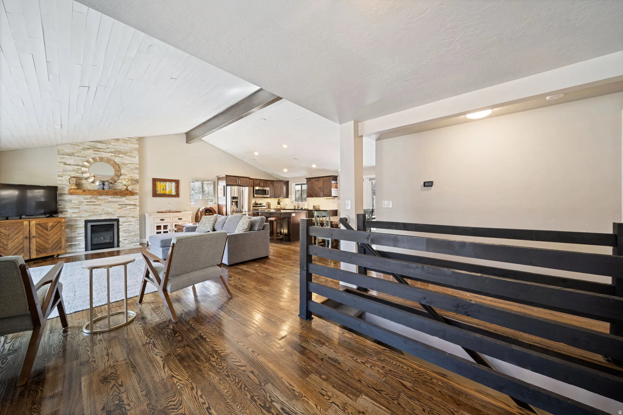 Staircase with wood finished floors, a fireplace, and beamed ceiling