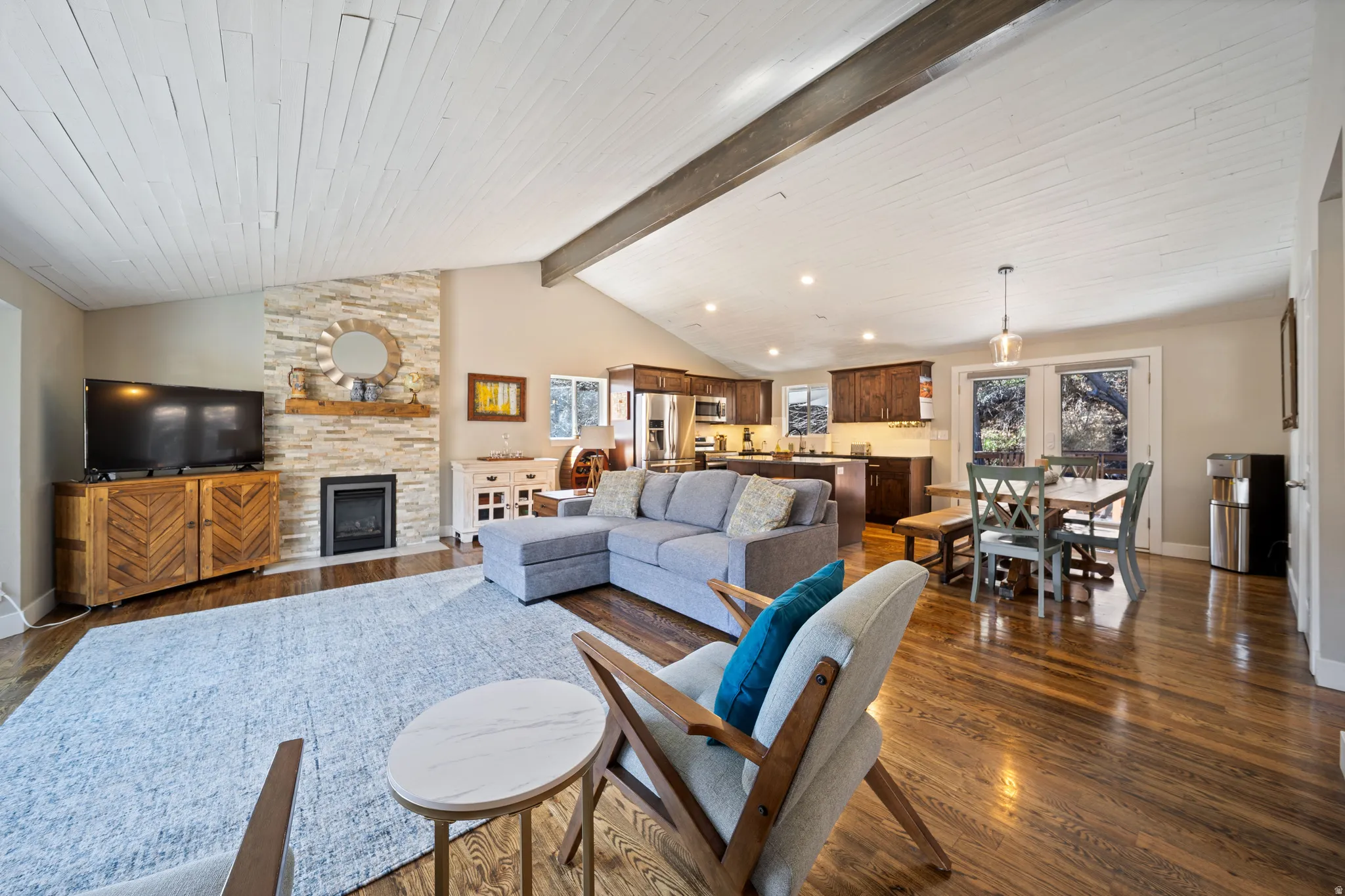 Living area with dark wood finished floors, a fireplace, and beam ceiling