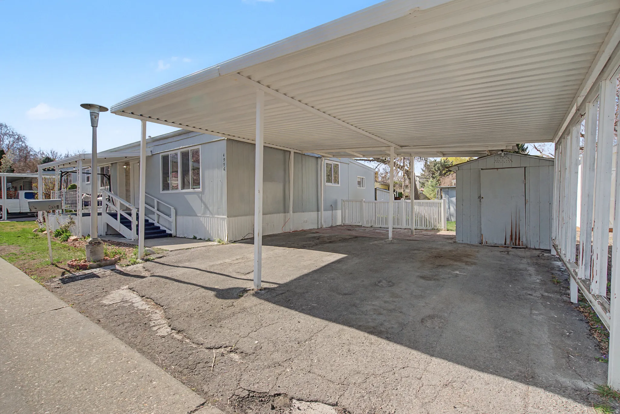 View of parking with a storage shed and a carport