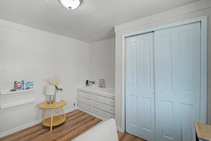 Bedroom featuring light wood-style flooring, a closet, and a textured ceiling
