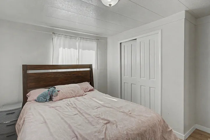 Bedroom featuring a closet, a textured ceiling, and wood finished floors