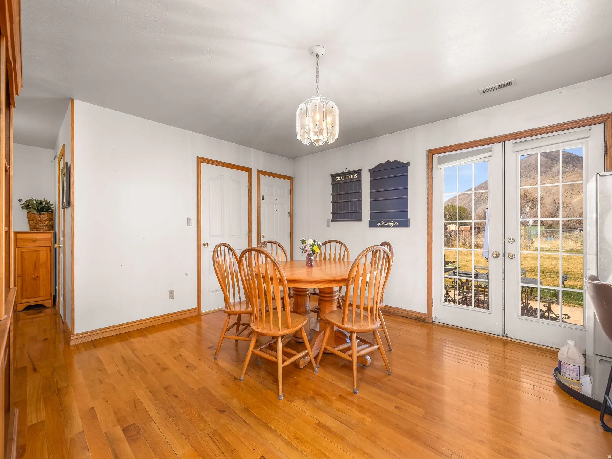 Dining room featuring light wood finished floors, suspended lighting, and french doors