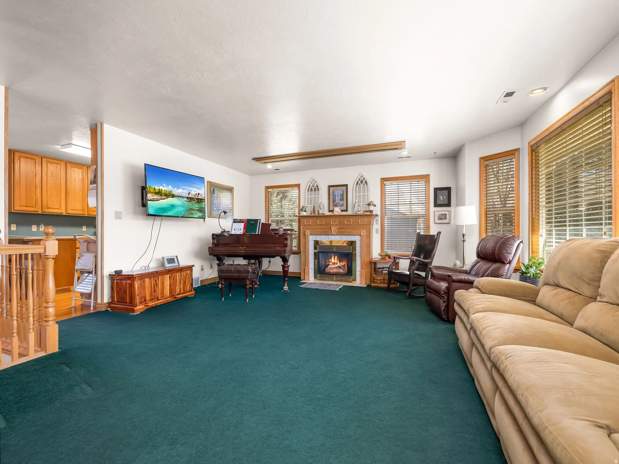 Carpeted living area featuring a tile fireplace