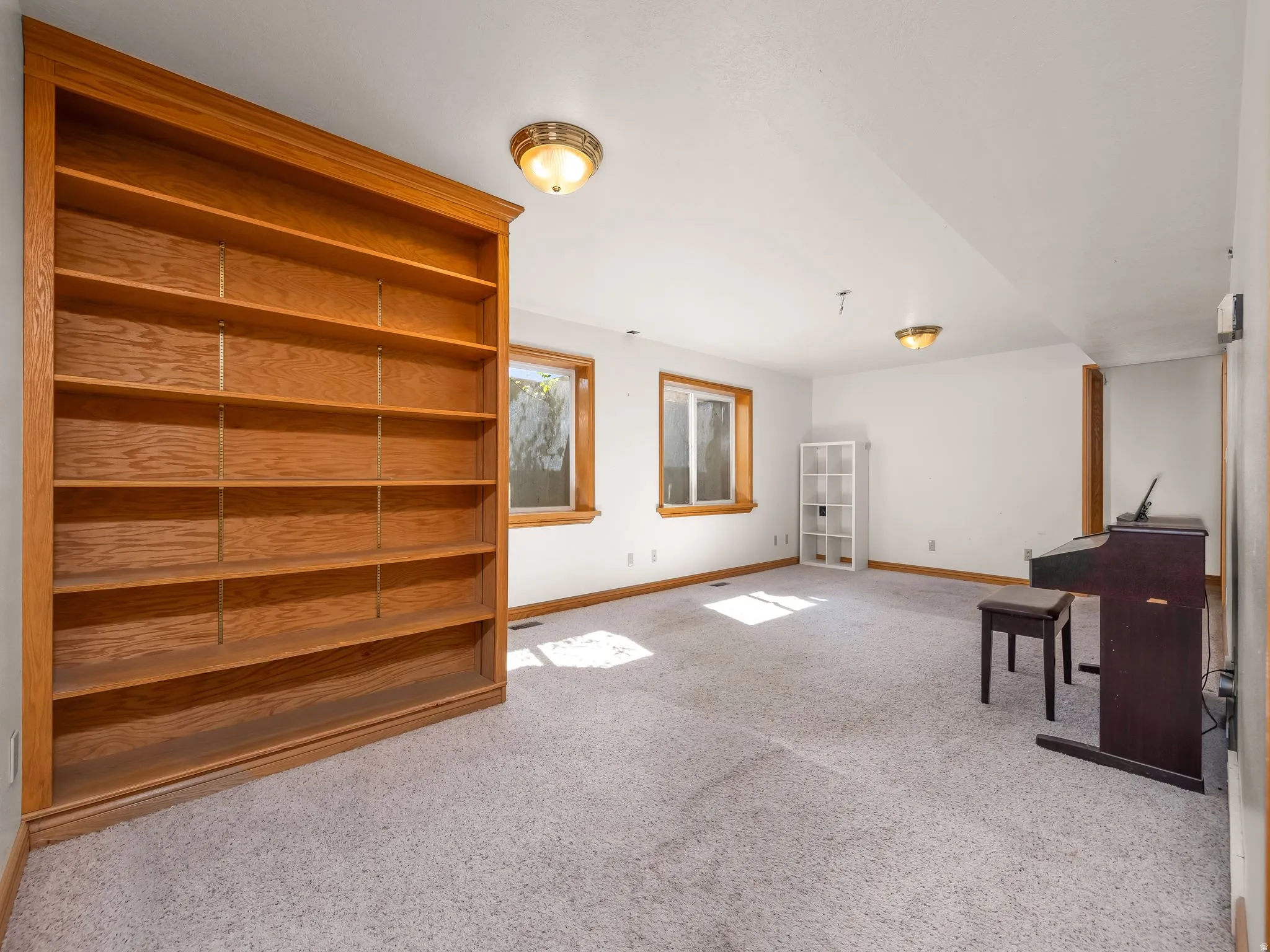 Basement with baseboards and light colored carpet