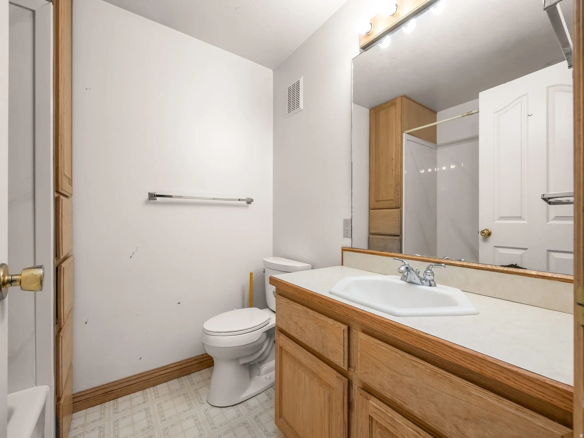 Bathroom featuring vanity, a shower, light floors, and a tub