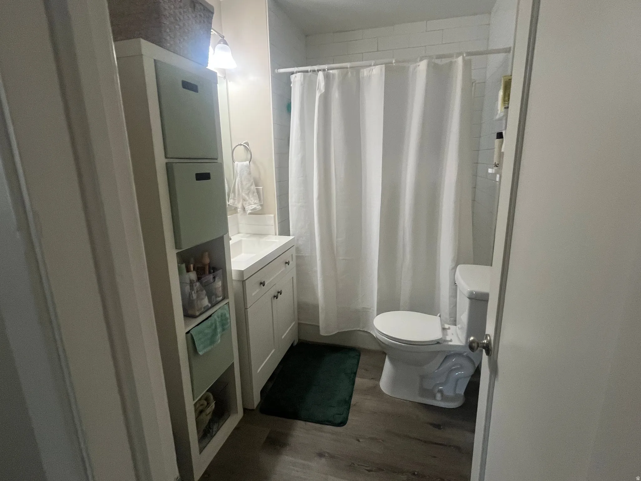 Bathroom with vanity, dark wood finished floors, and shower / tub combo