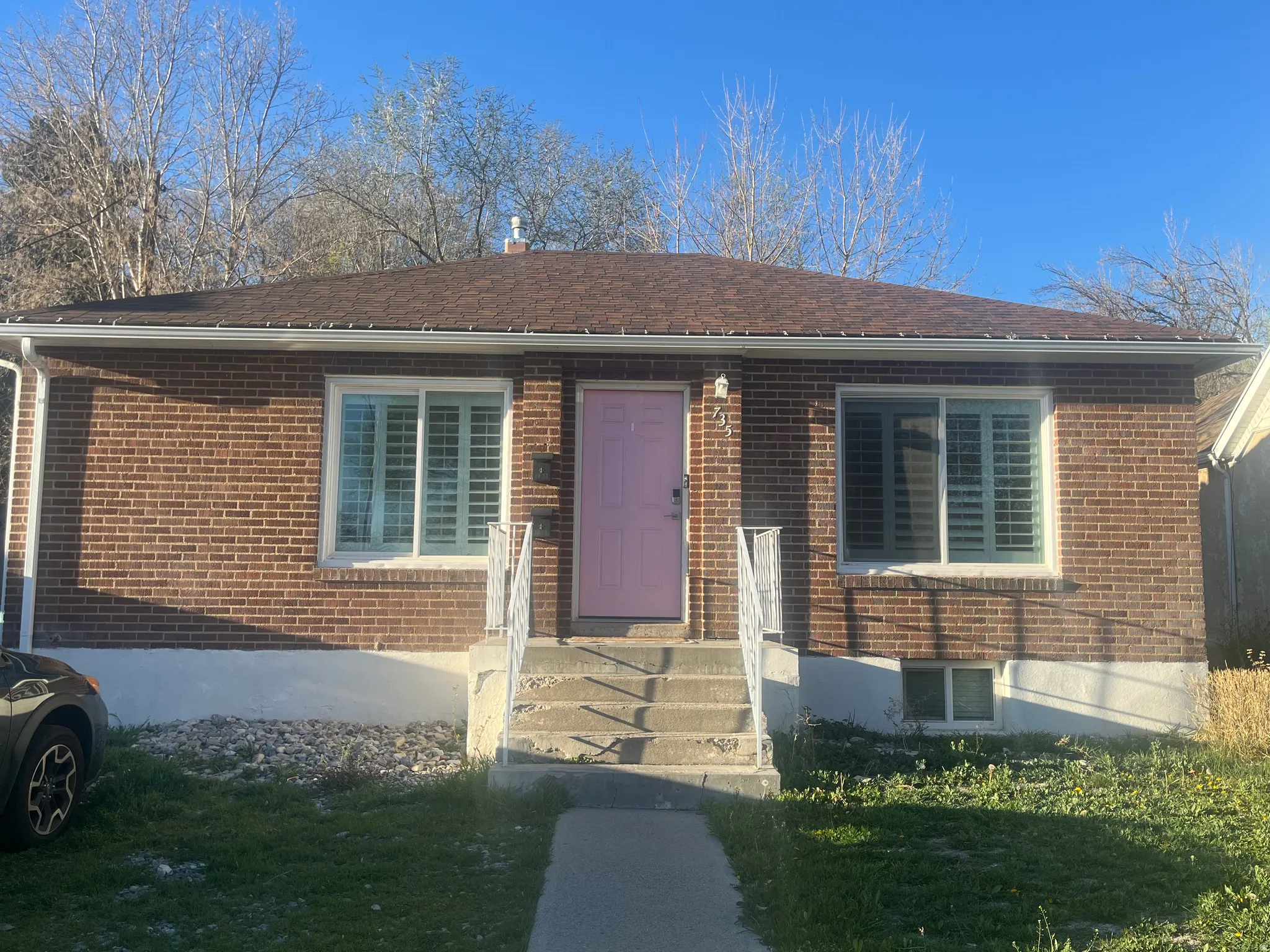 View of exterior entry with brick siding and a yard