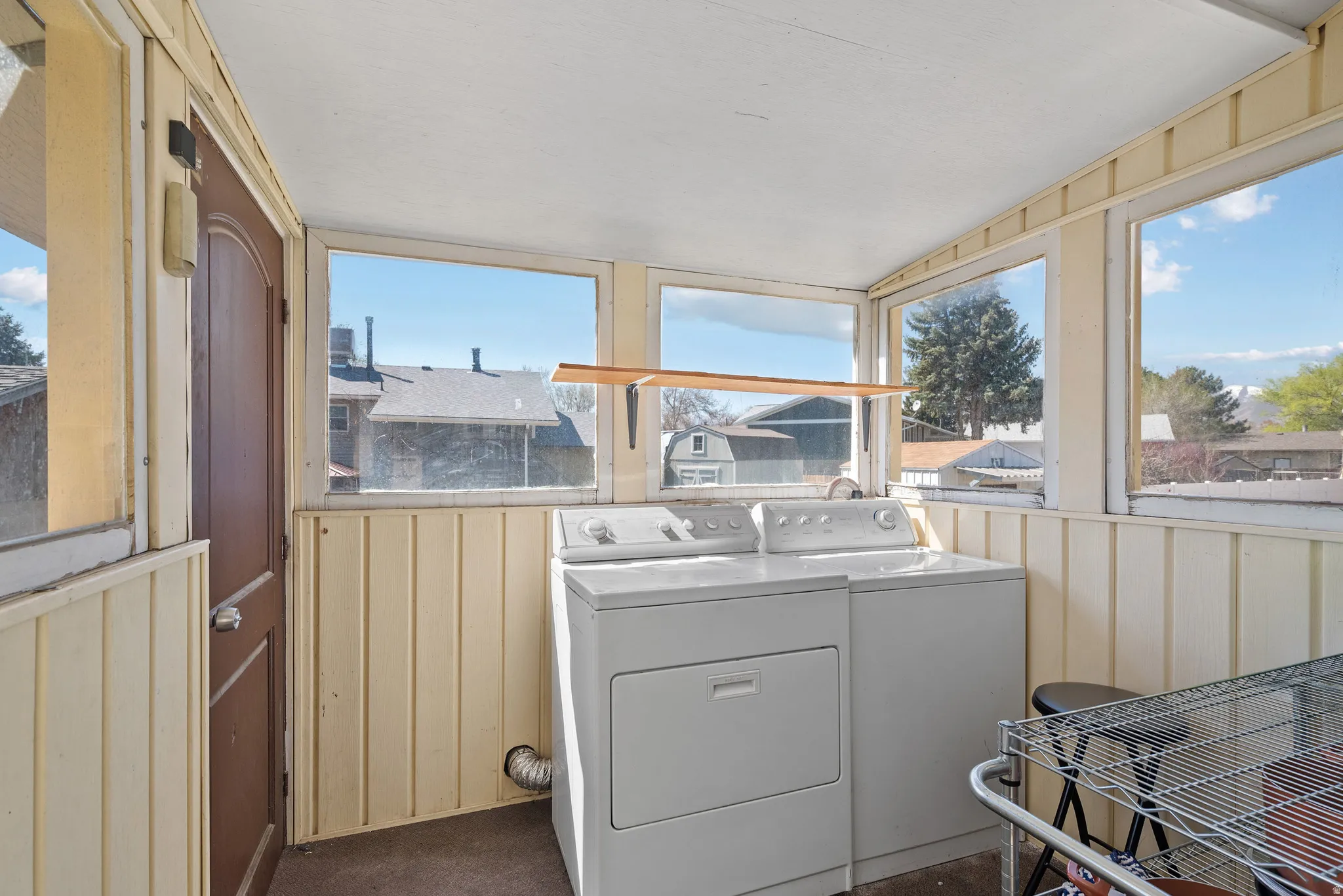 Laundry area featuring plenty of natural light, washer and dryer, and wooden walls