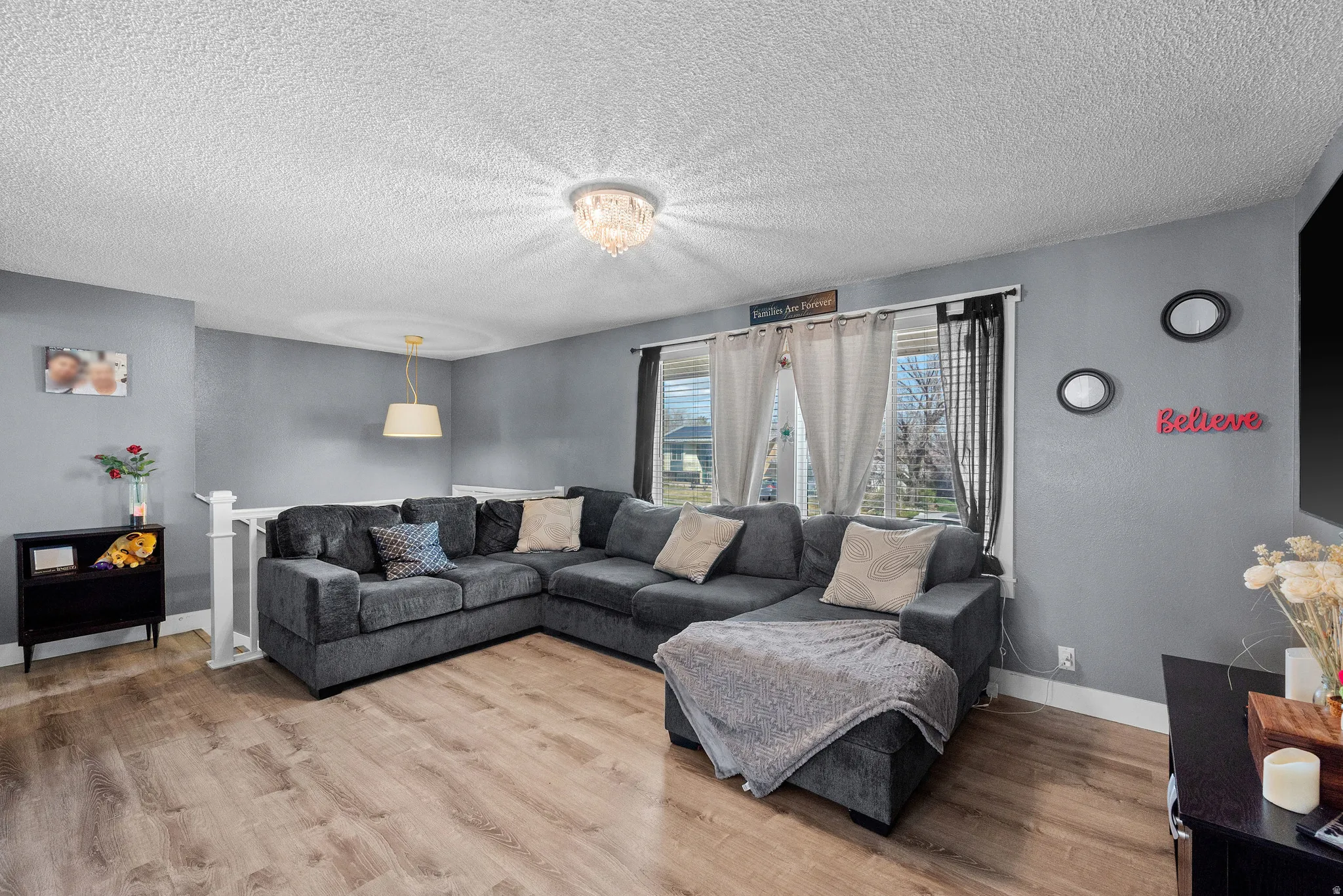 Living area with light wood finished floors and a textured ceiling