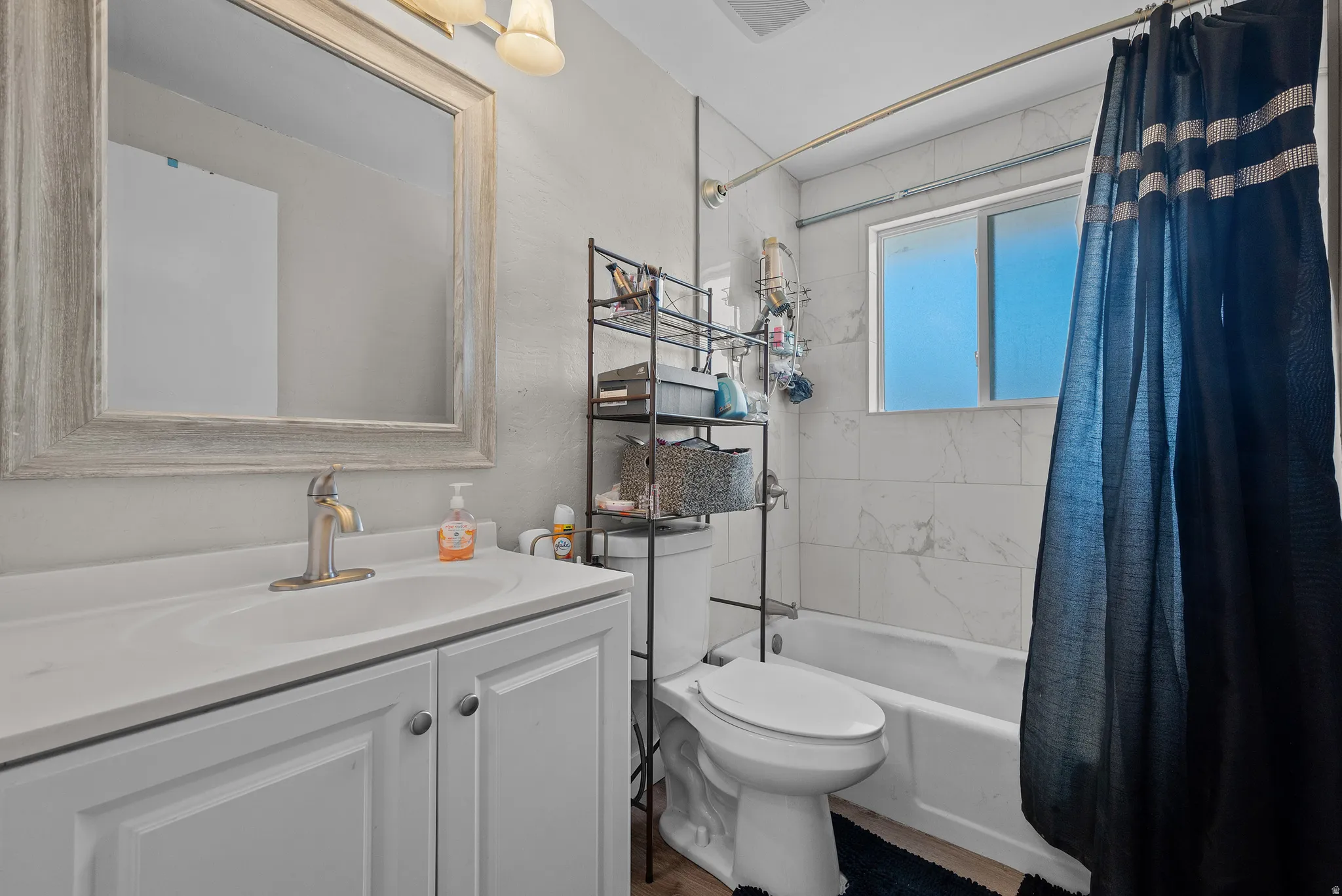 Bathroom with vanity and shower / bath combination with curtain