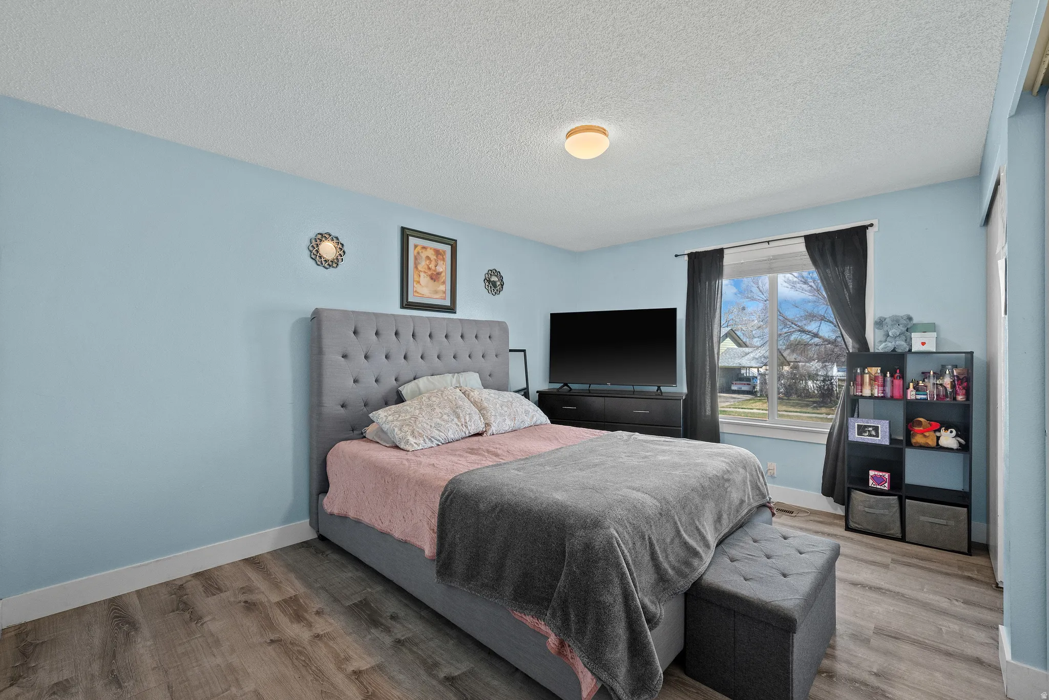 Bedroom featuring a textured ceiling and light wood-style floors