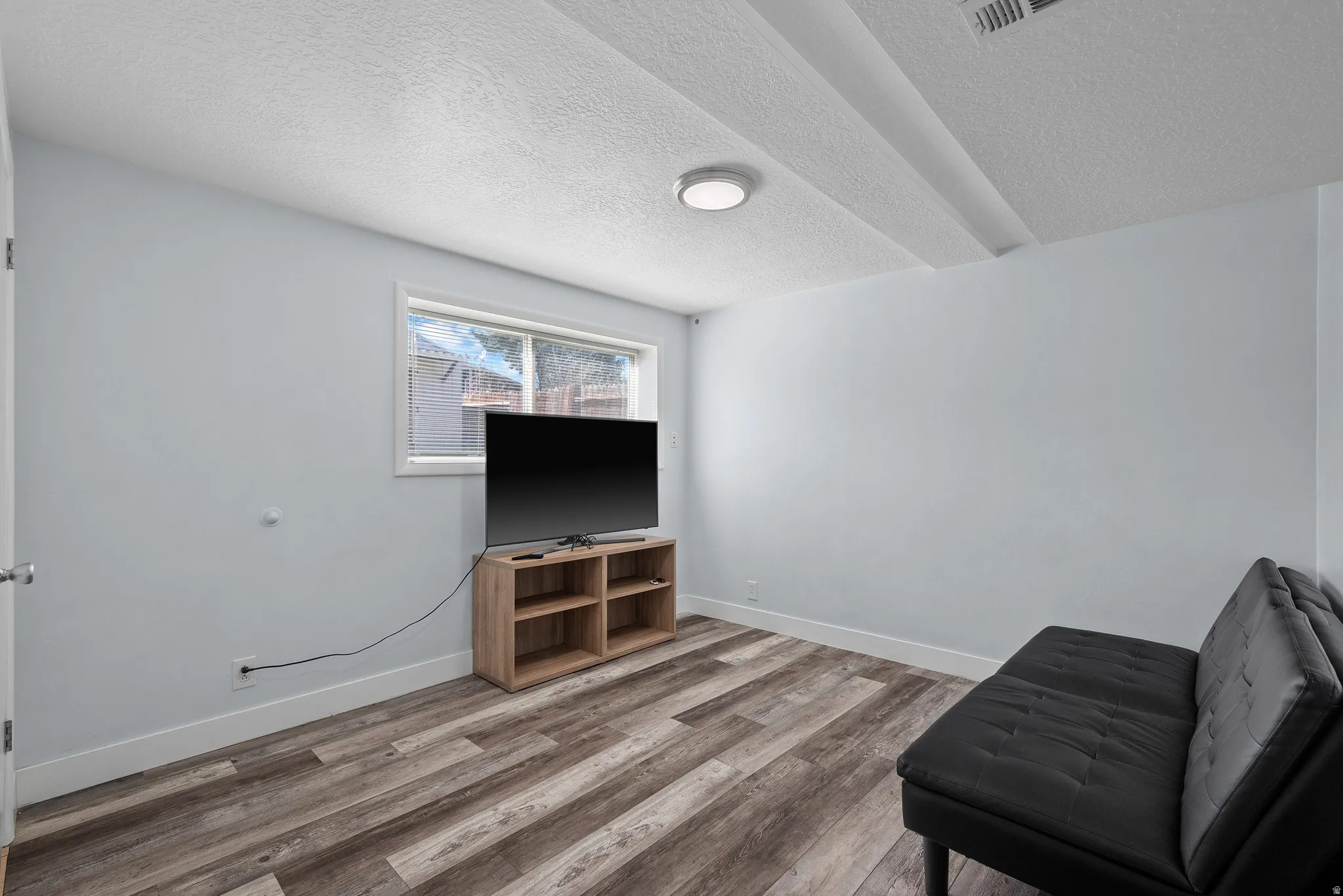 Living area with wood finished floors and a textured ceiling