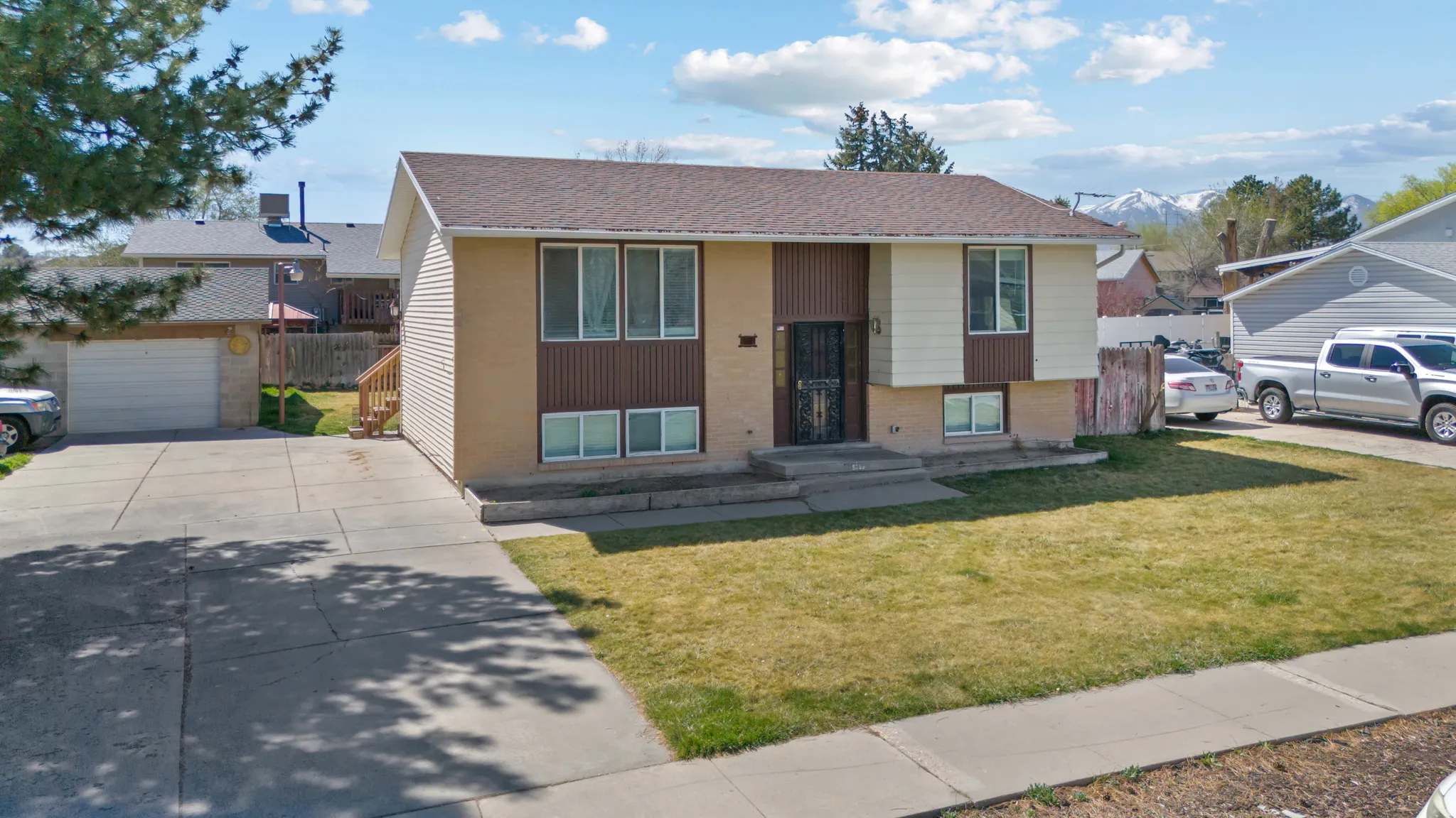 Split foyer home with brick siding, concrete driveway, and roof with shingles