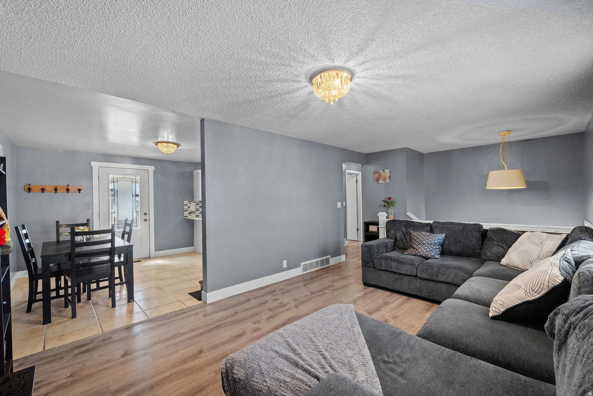 Living area with light wood finished floors and a textured ceiling