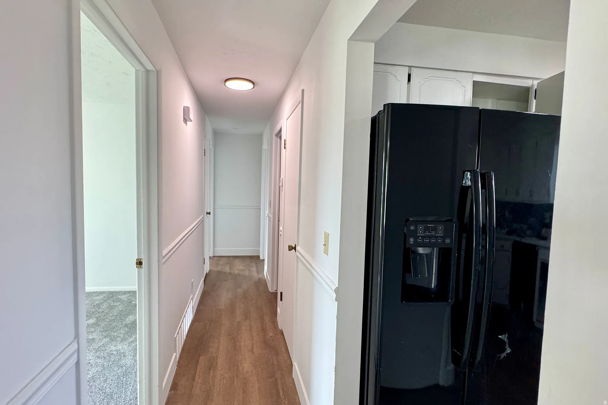 Hall with baseboards and light wood finished floors