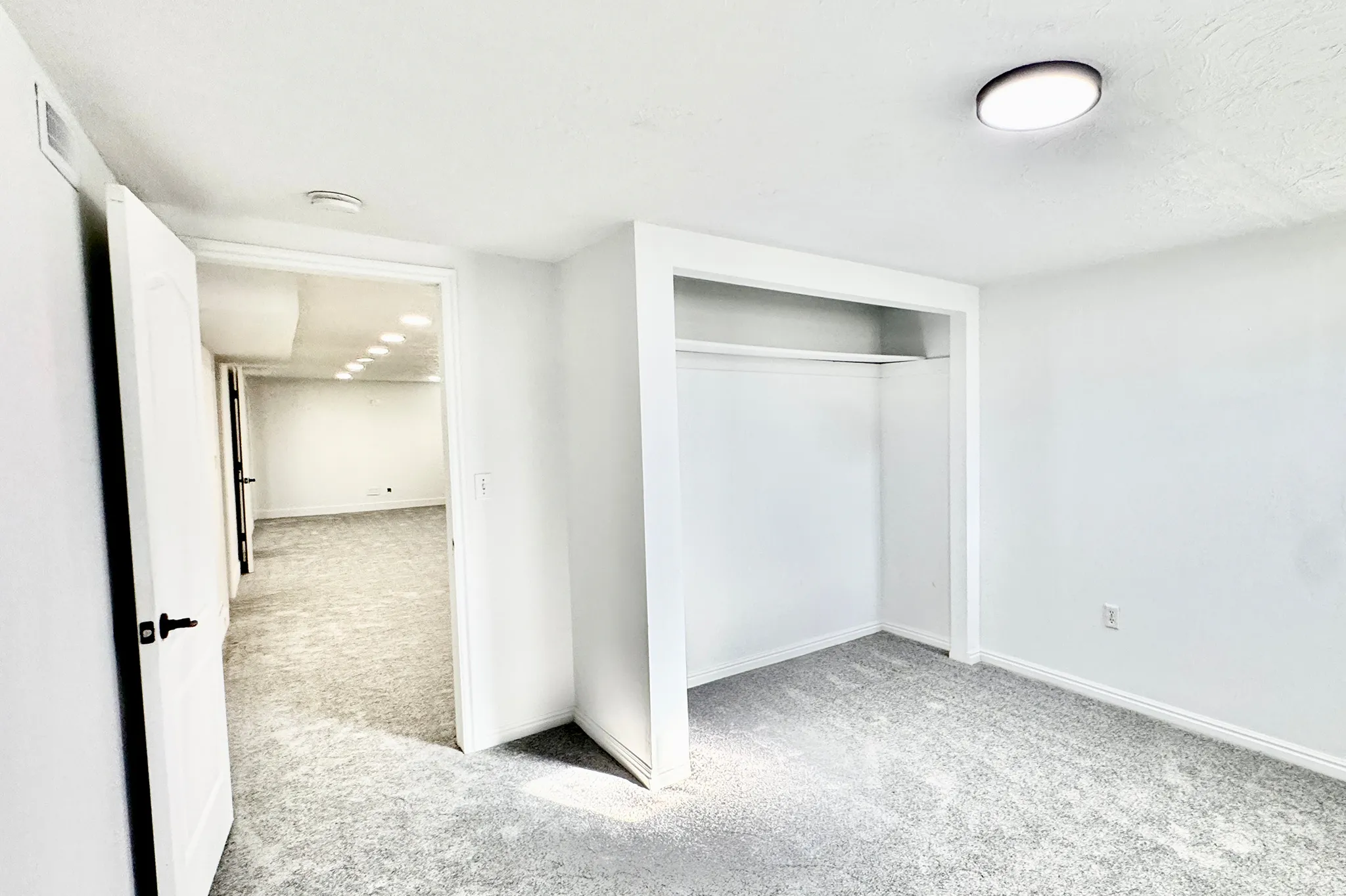 Unfurnished bedroom with light colored carpet and a closet