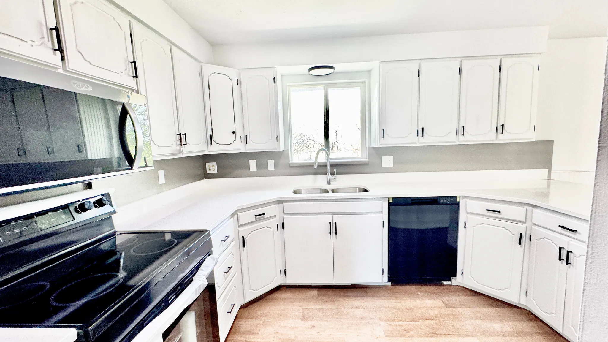Kitchen featuring stainless steel appliances, white cabinetry, and light wood-style floors