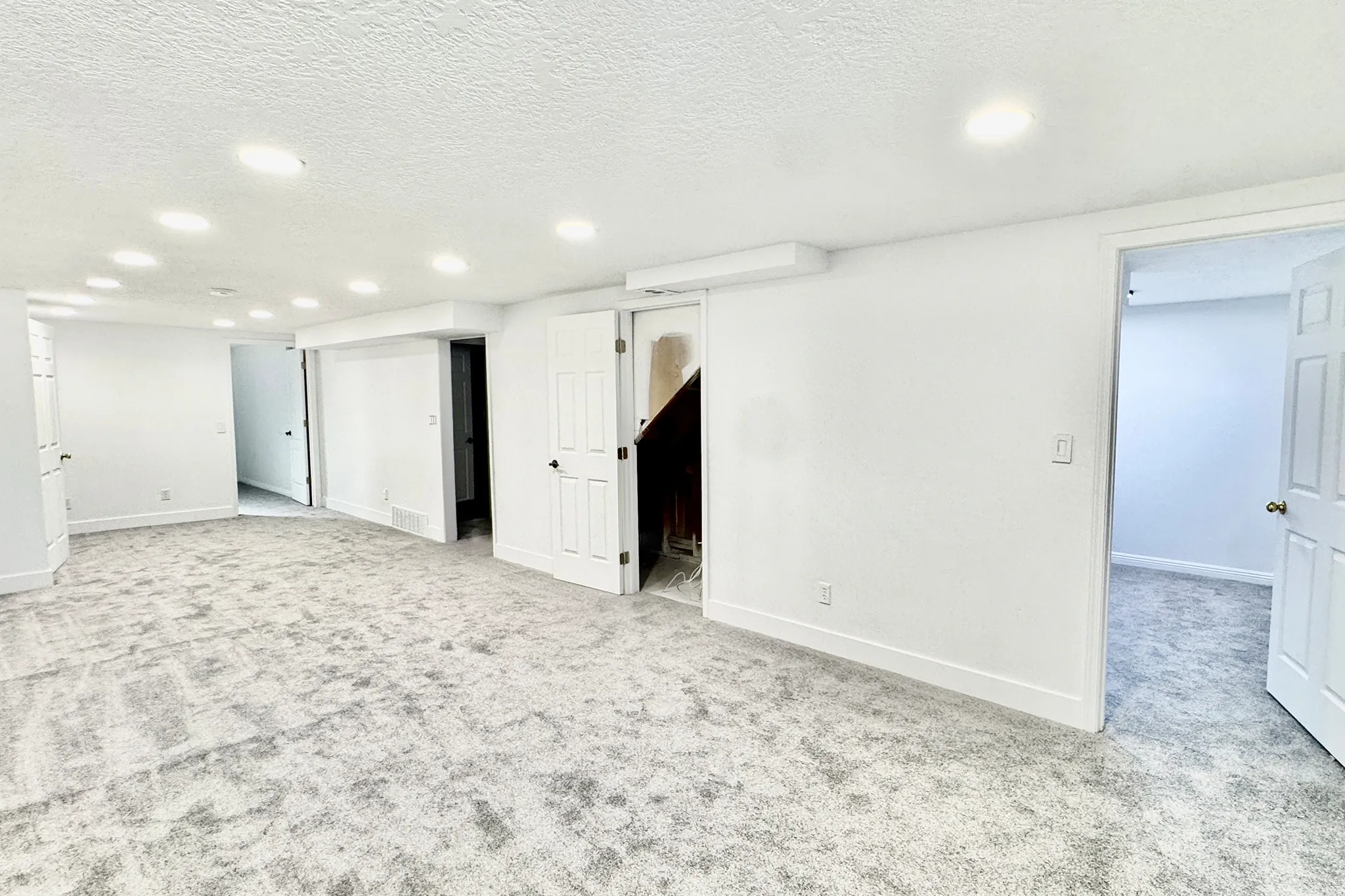 Finished basement with a textured ceiling, light carpet, and recessed lighting