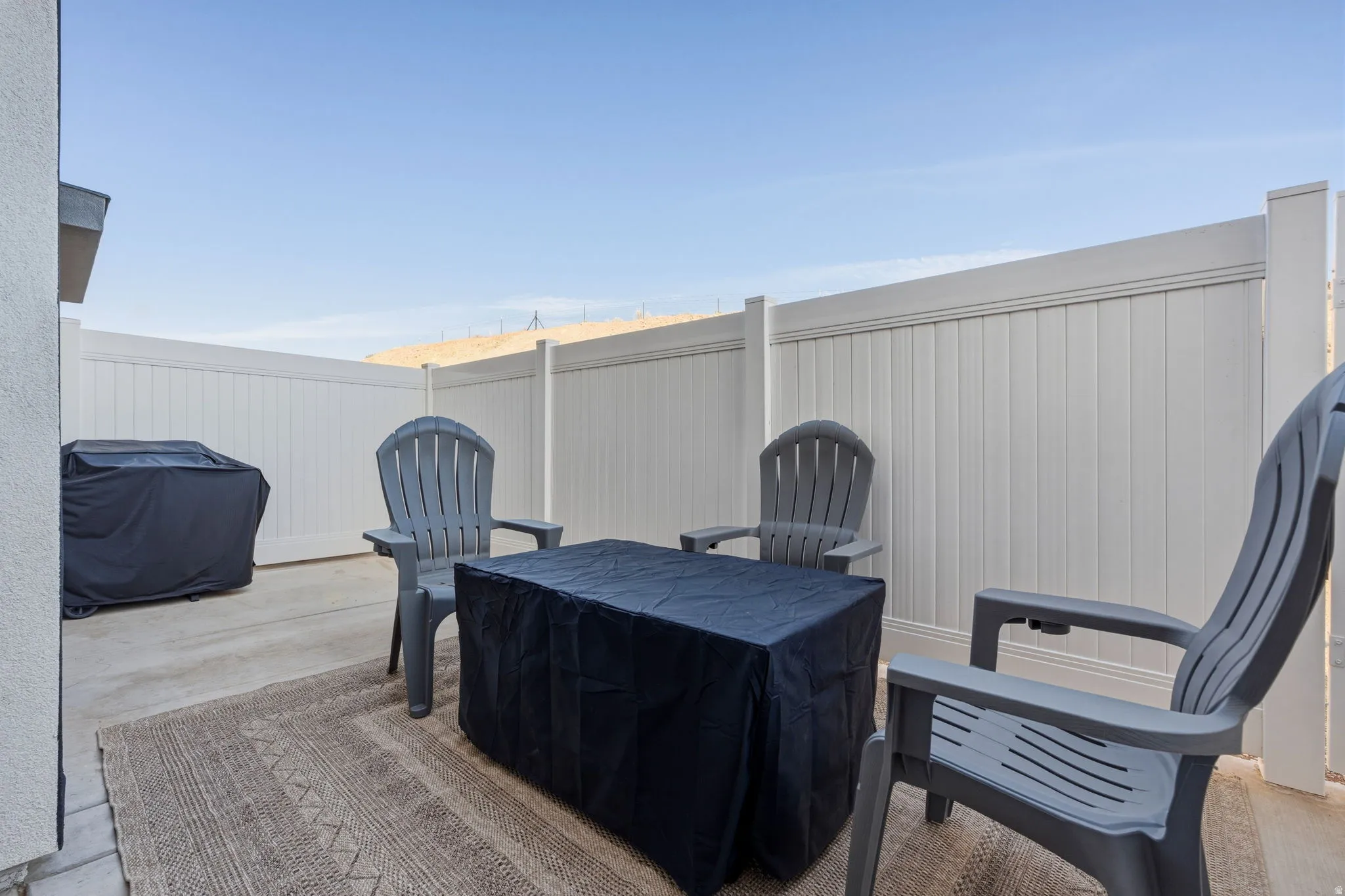 Fenced backyard with a grill and a patio area