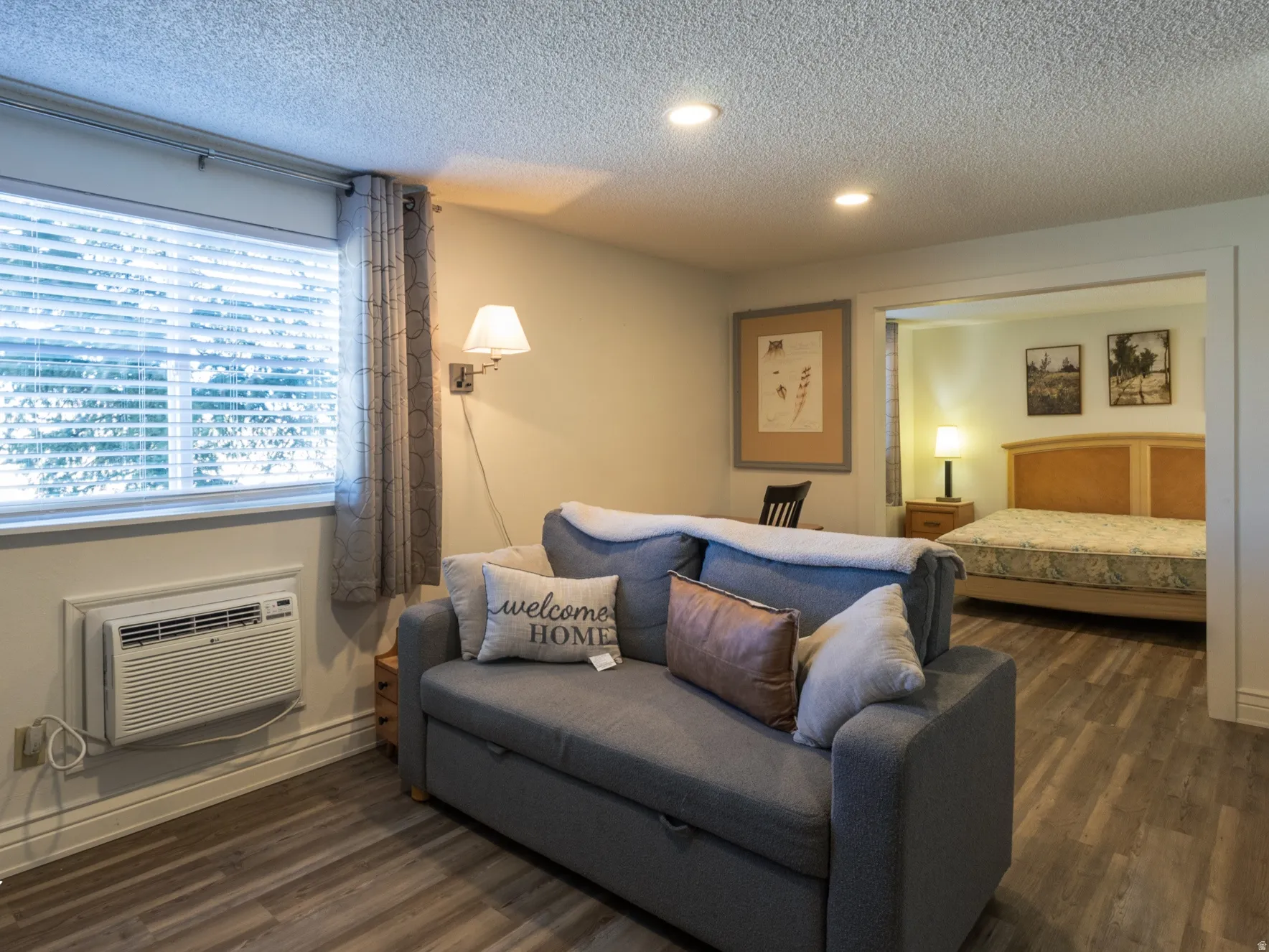 Bedroom with dark wood-type flooring, a textured ceiling, and recessed lighting