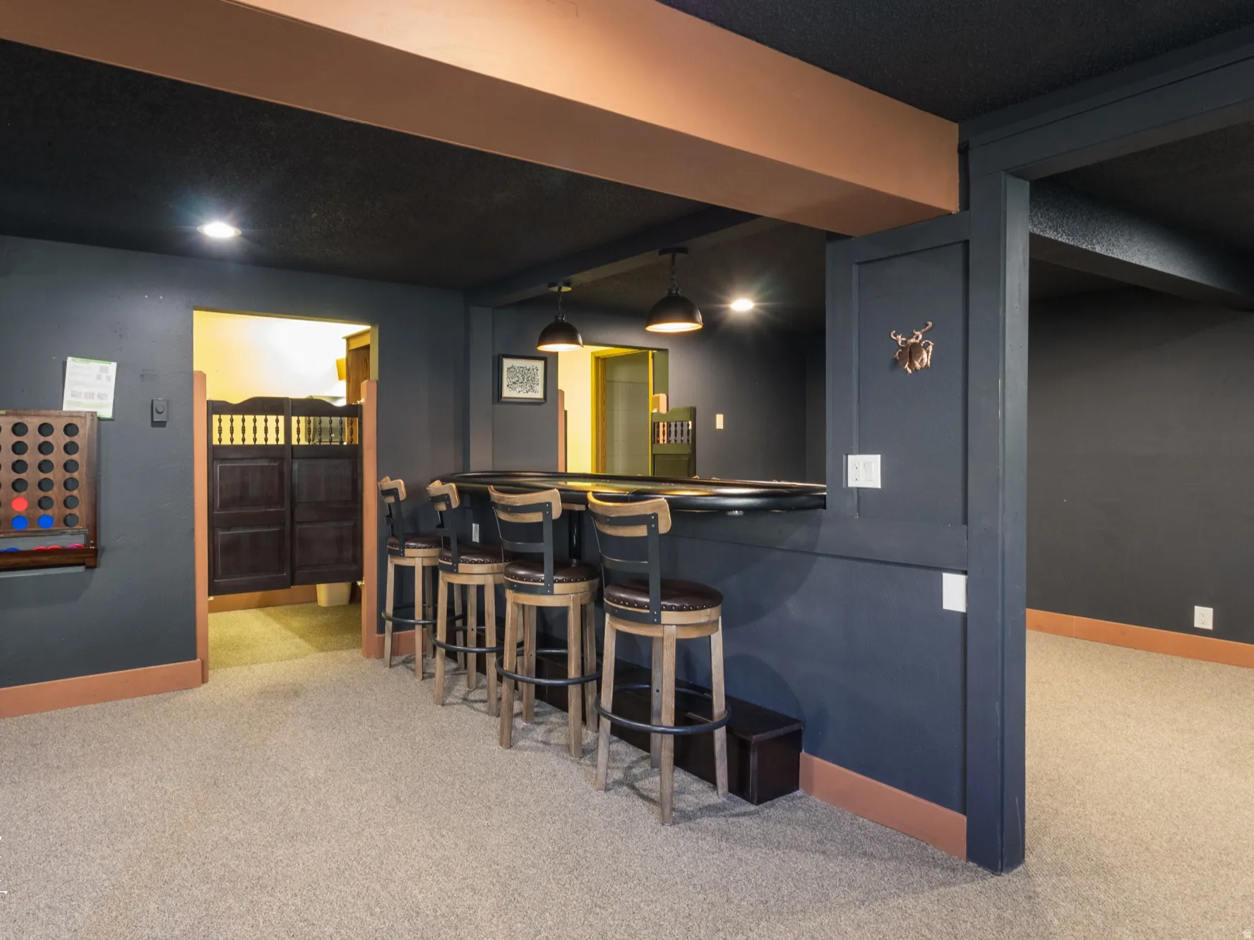 Indoor dry bar featuring decorative light fixtures and dark countertops