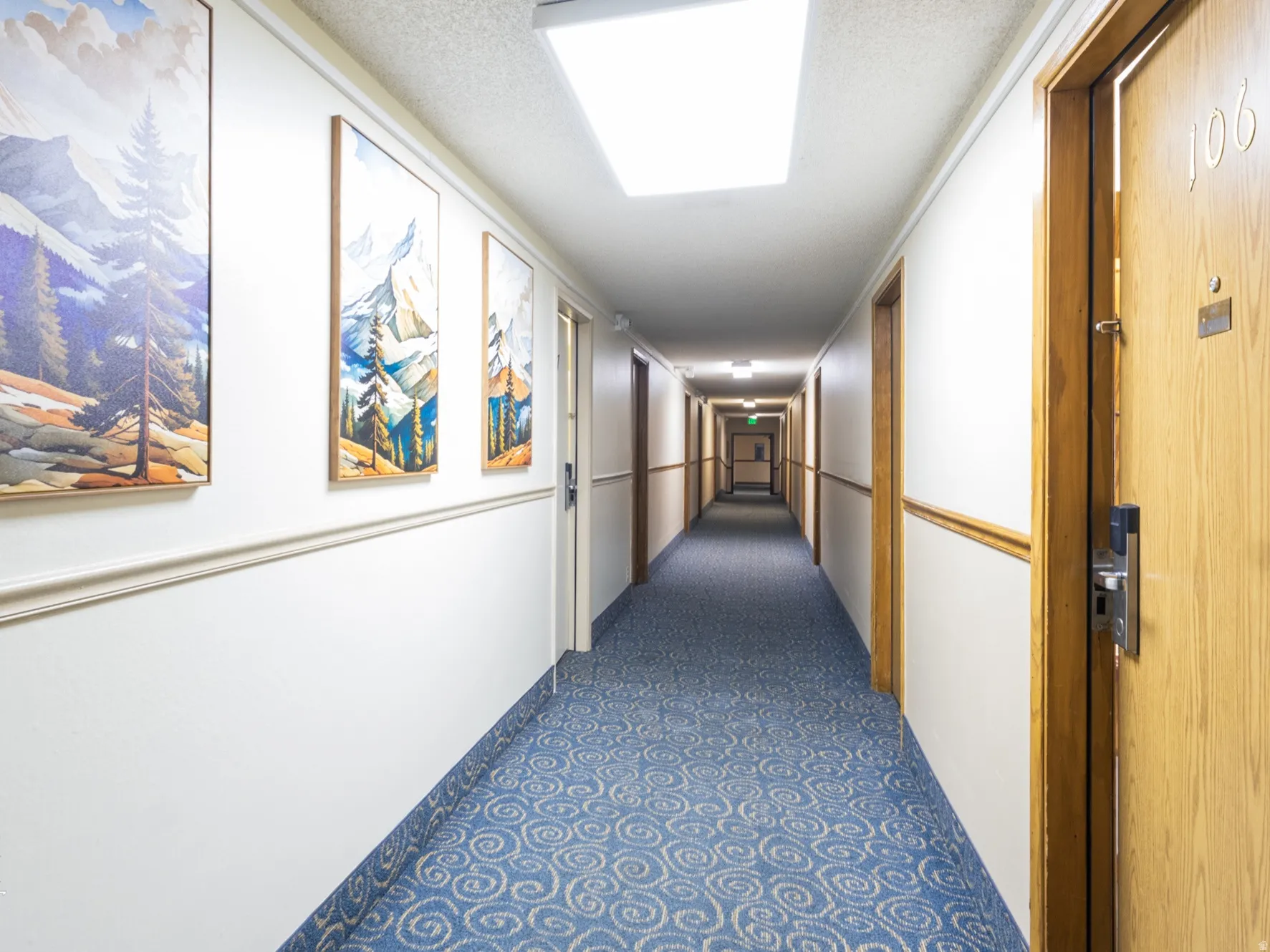 Hall featuring a textured ceiling and dark flooring