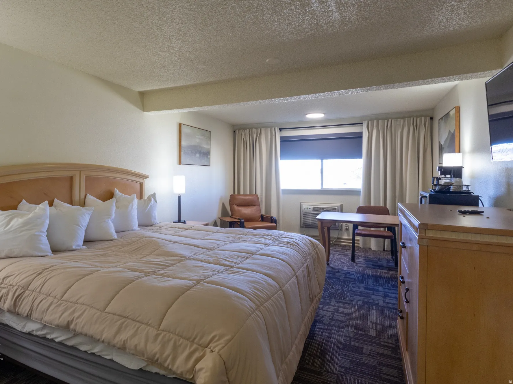 Bedroom featuring a textured ceiling, dark colored carpet, and recessed lighting