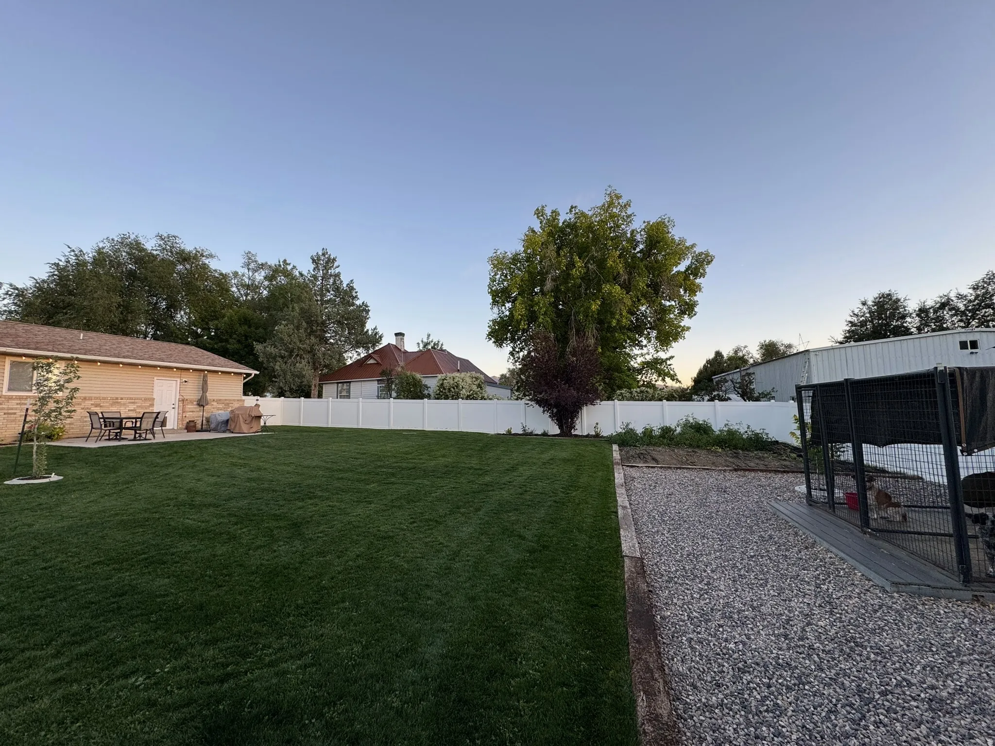 Fenced backyard with a patio area and an outbuilding