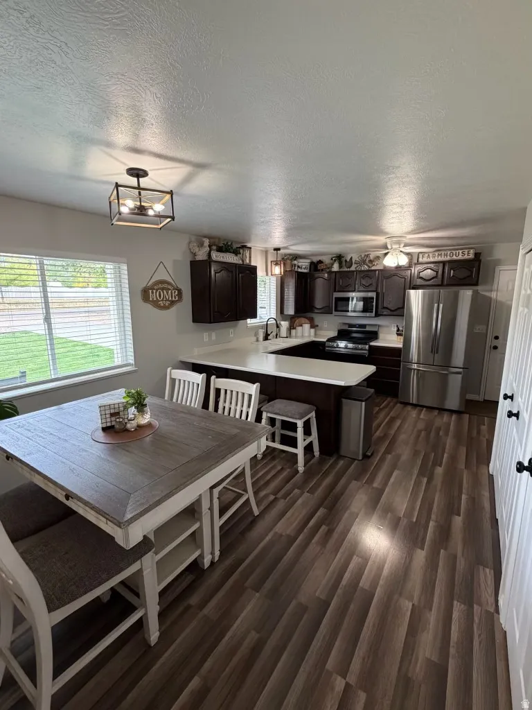 Dining area featuring a textured ceiling and dark wood-type flooring