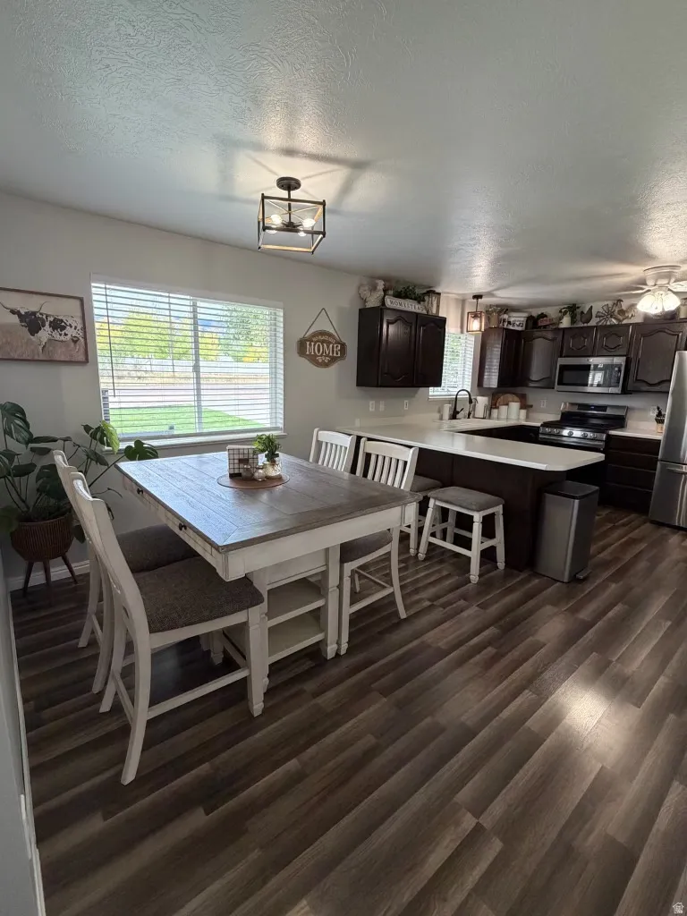 Dining space featuring a textured ceiling, dark wood-type flooring, and ceiling fan