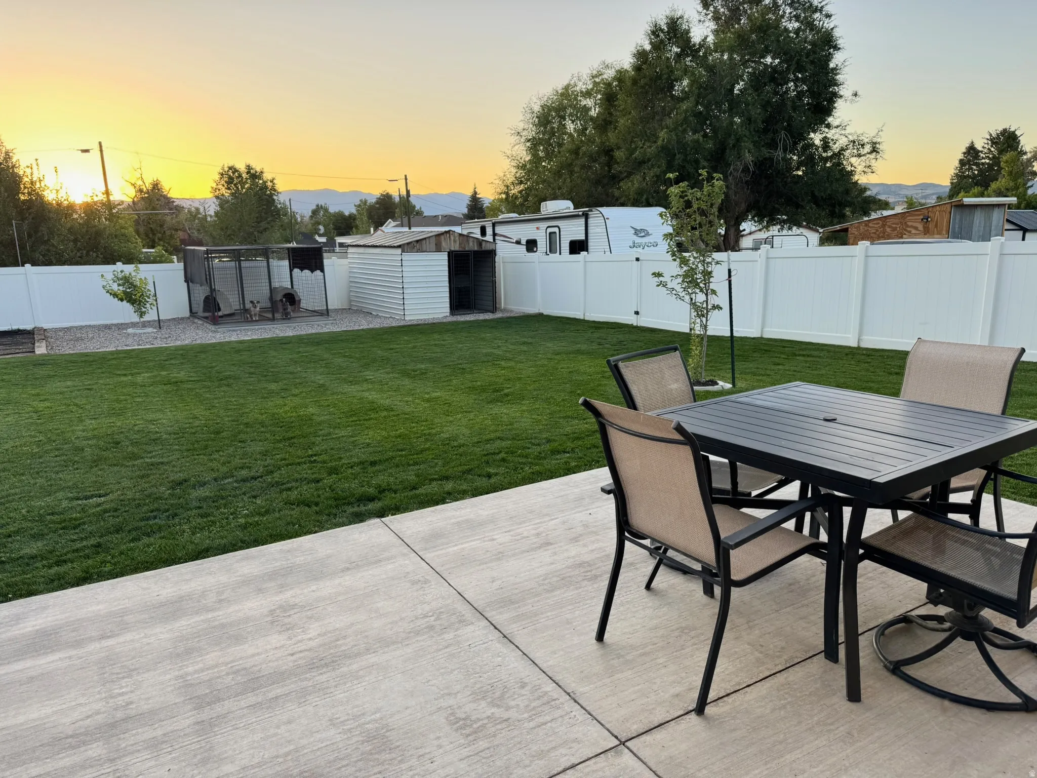 Fenced backyard featuring a patio area, outdoor dining space, and an outdoor structure