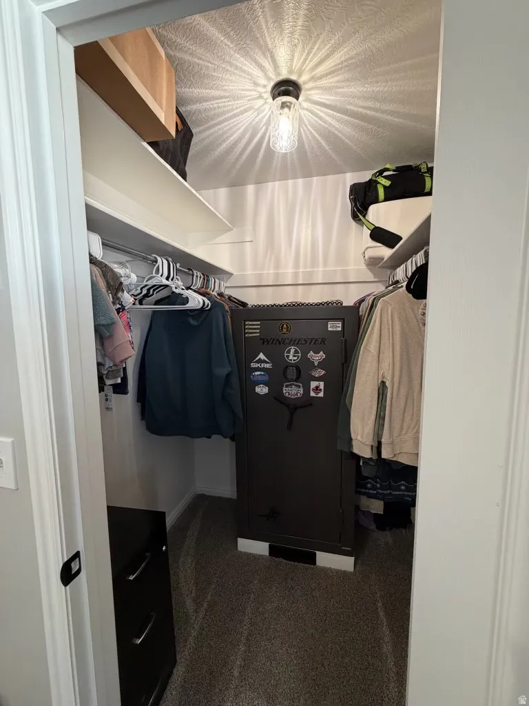 Walk in closet featuring dark carpet