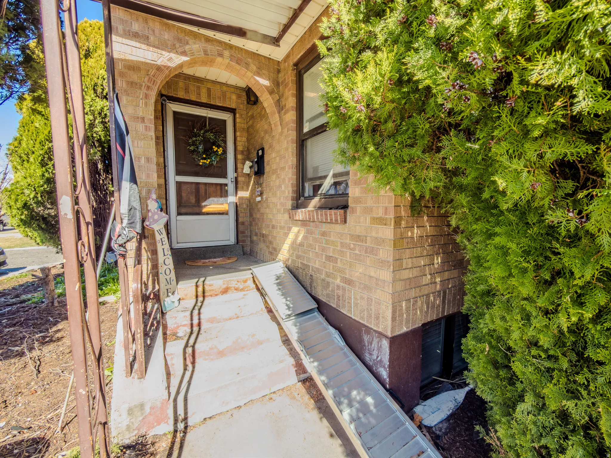Property entrance featuring brick siding and covered porch
