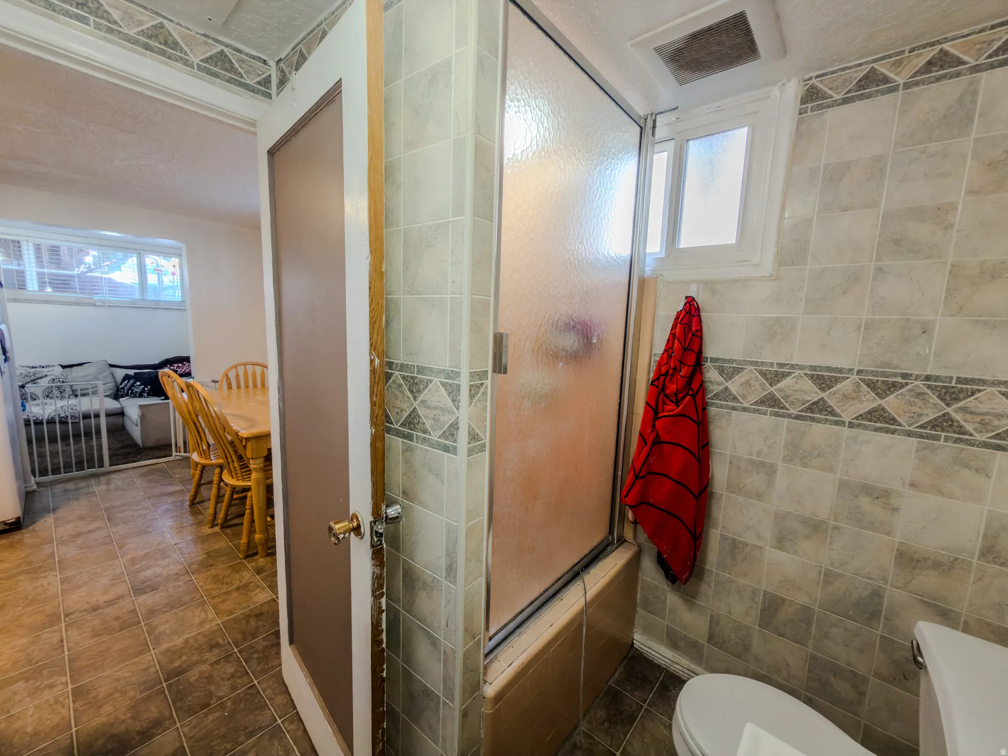 Full bath featuring toilet and enclosed tub / shower combo