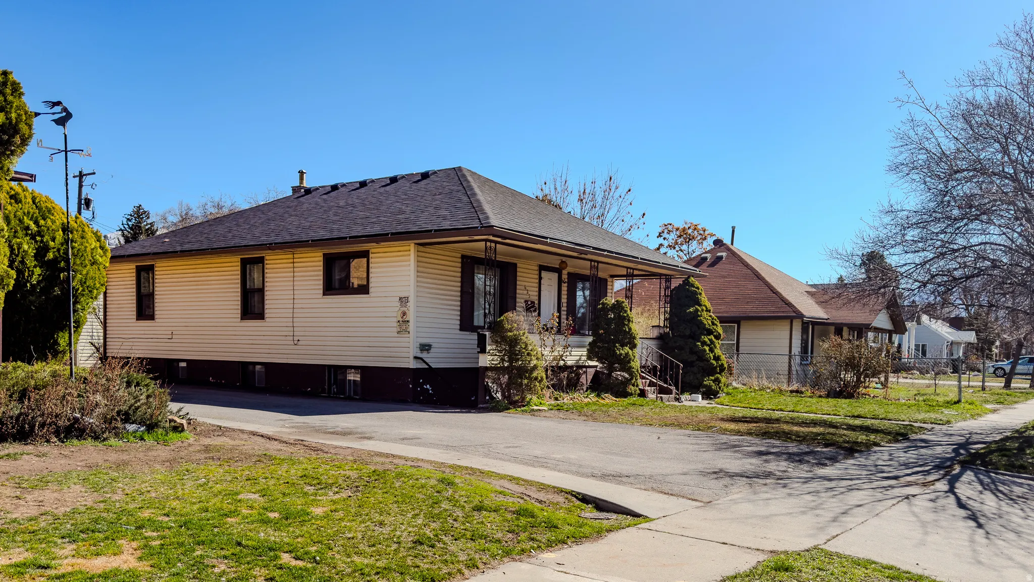 View of front facade with a porch, asphalt driveway, and roof with shingles