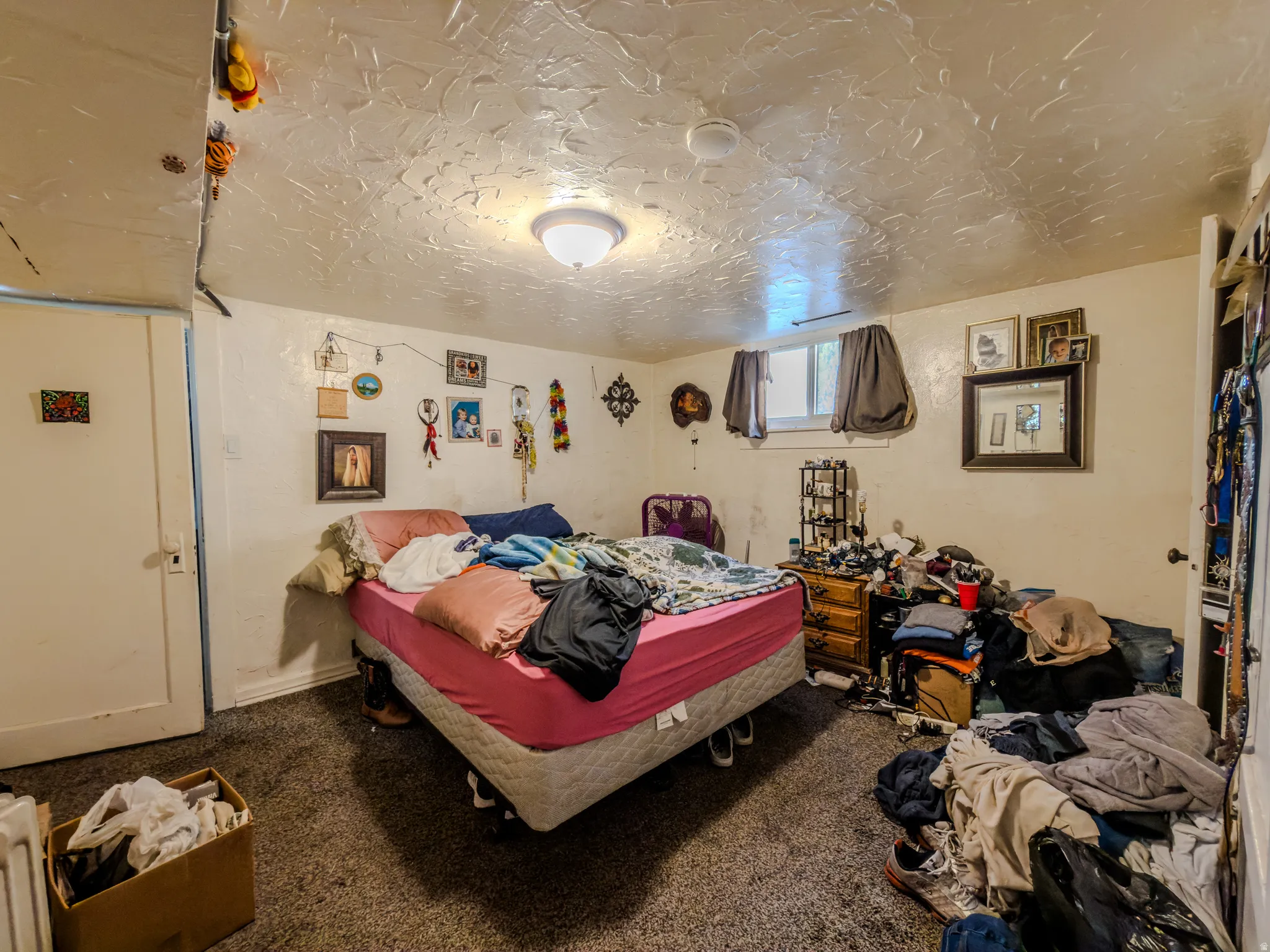 Bedroom with dark carpet, a textured ceiling, and radiator