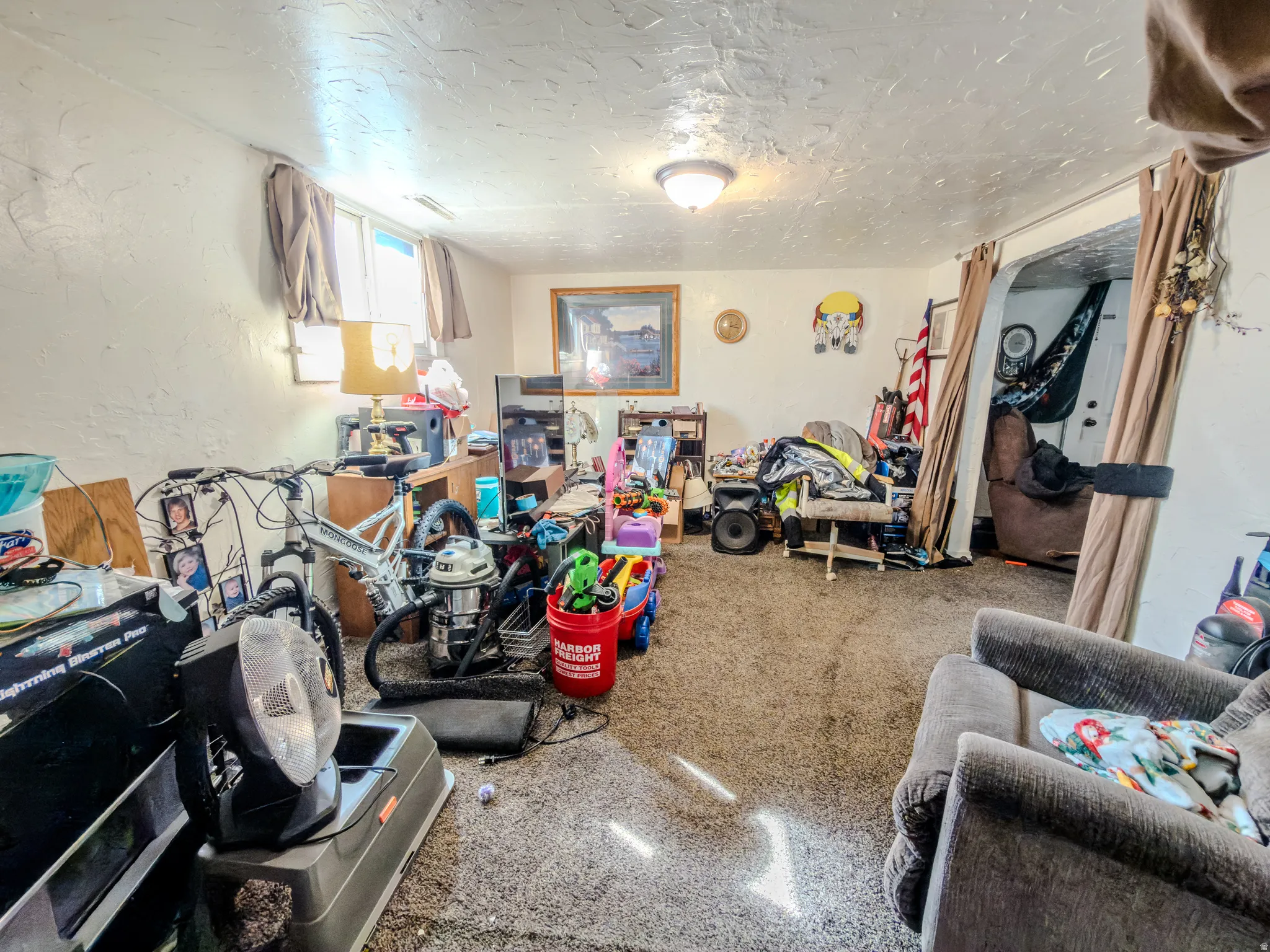 Rec room featuring a textured ceiling and a textured wall