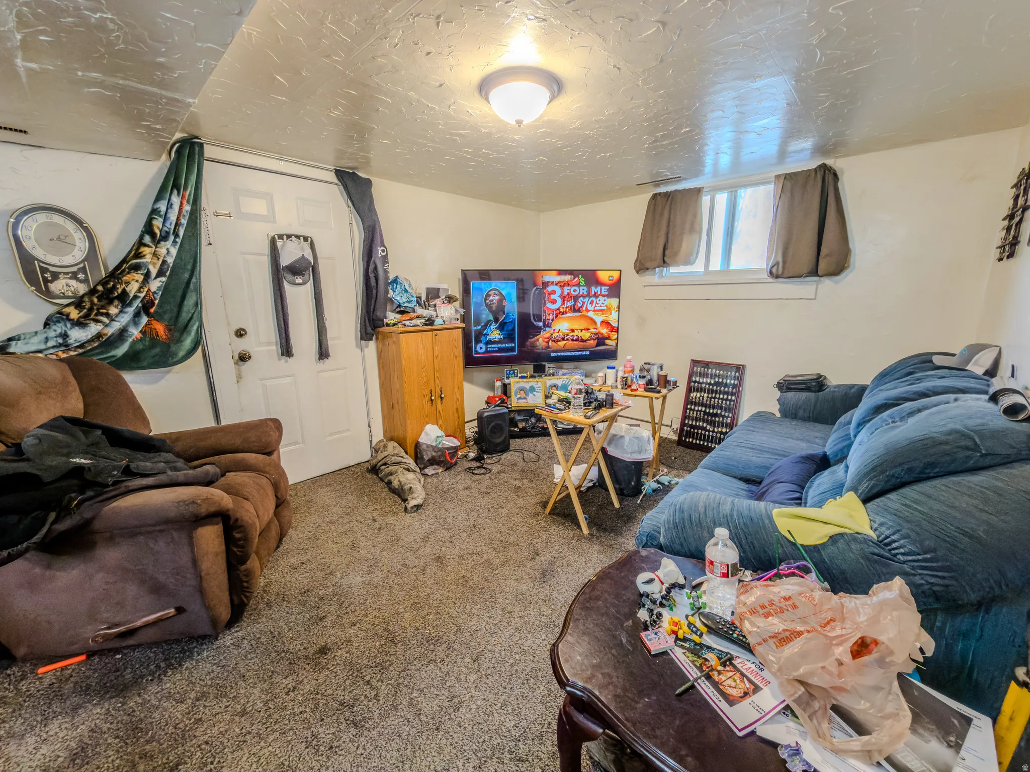 Carpeted living room featuring a textured ceiling
