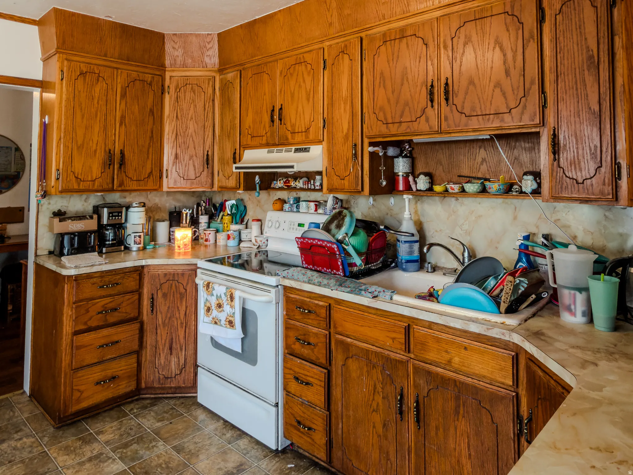 Kitchen featuring electric range, light countertops, and wood finish cabinetry
