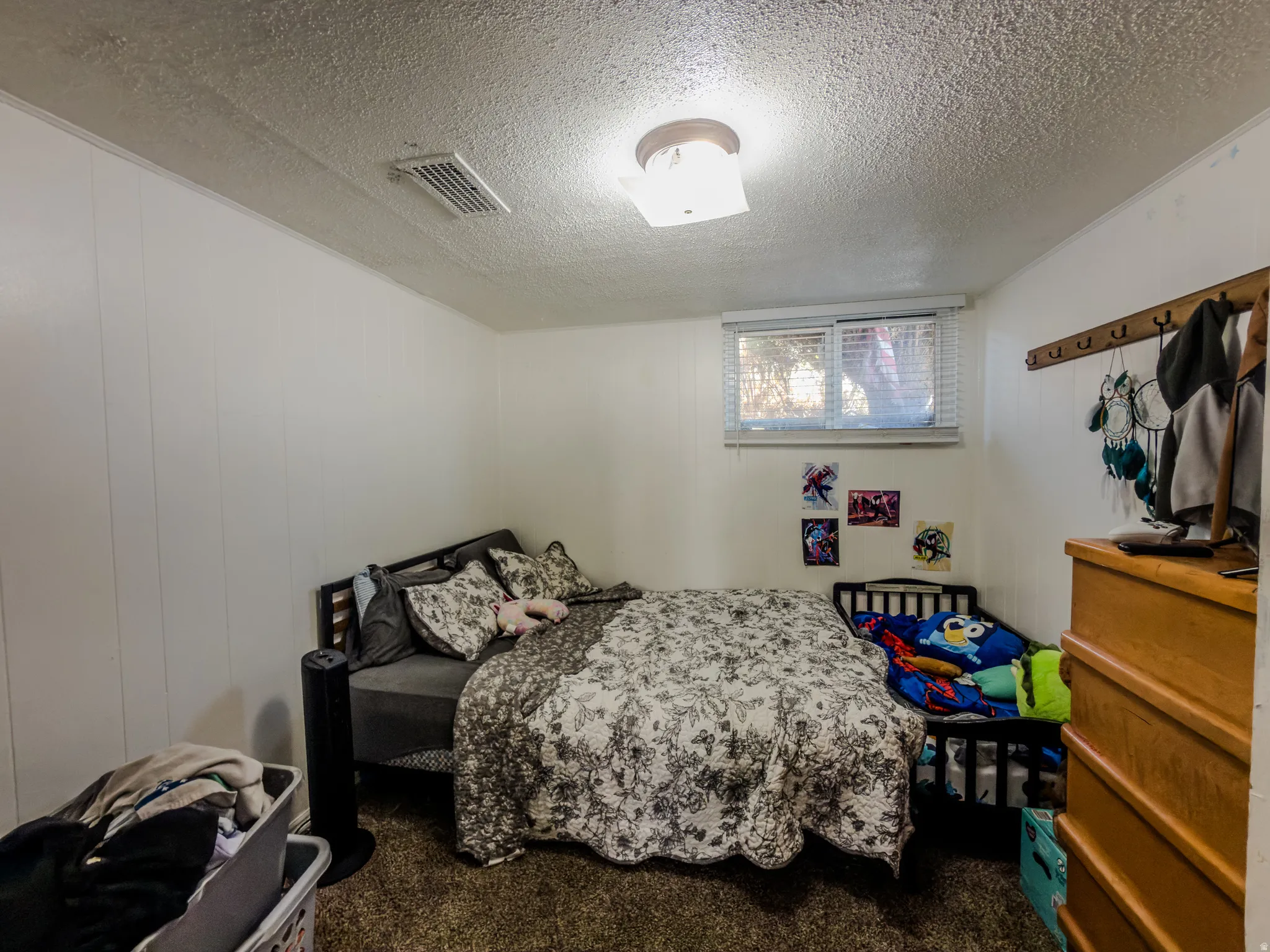 Bedroom with dark carpet and a textured ceiling